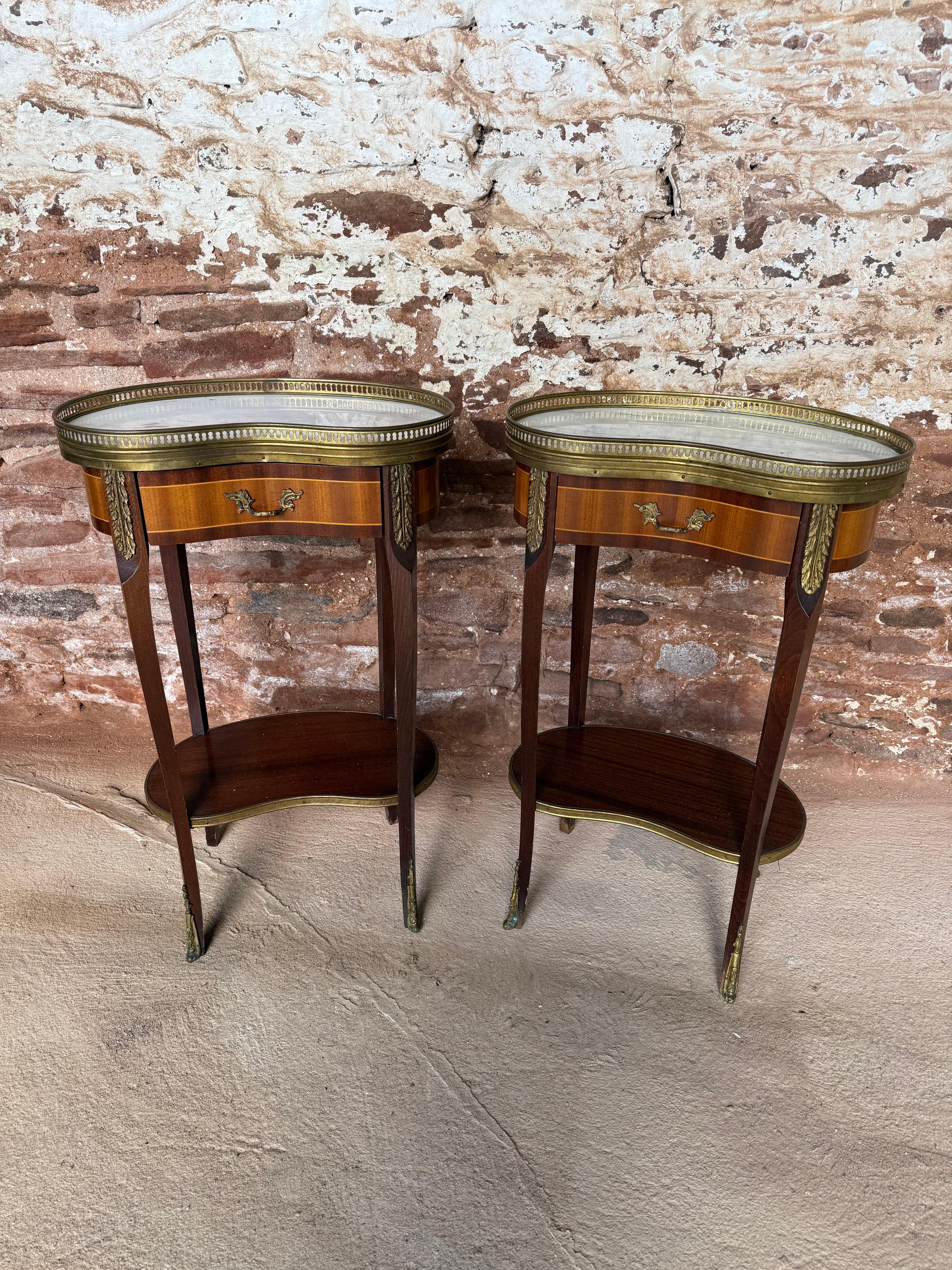 Coppia di comodini a forma di rene molto decorativi degli anni '60 

Con piani originali in marmo e montature in ormù 

Altezza 27,5 pollici 

Larghezza 17 pollici 

Profondità 11 pollici 