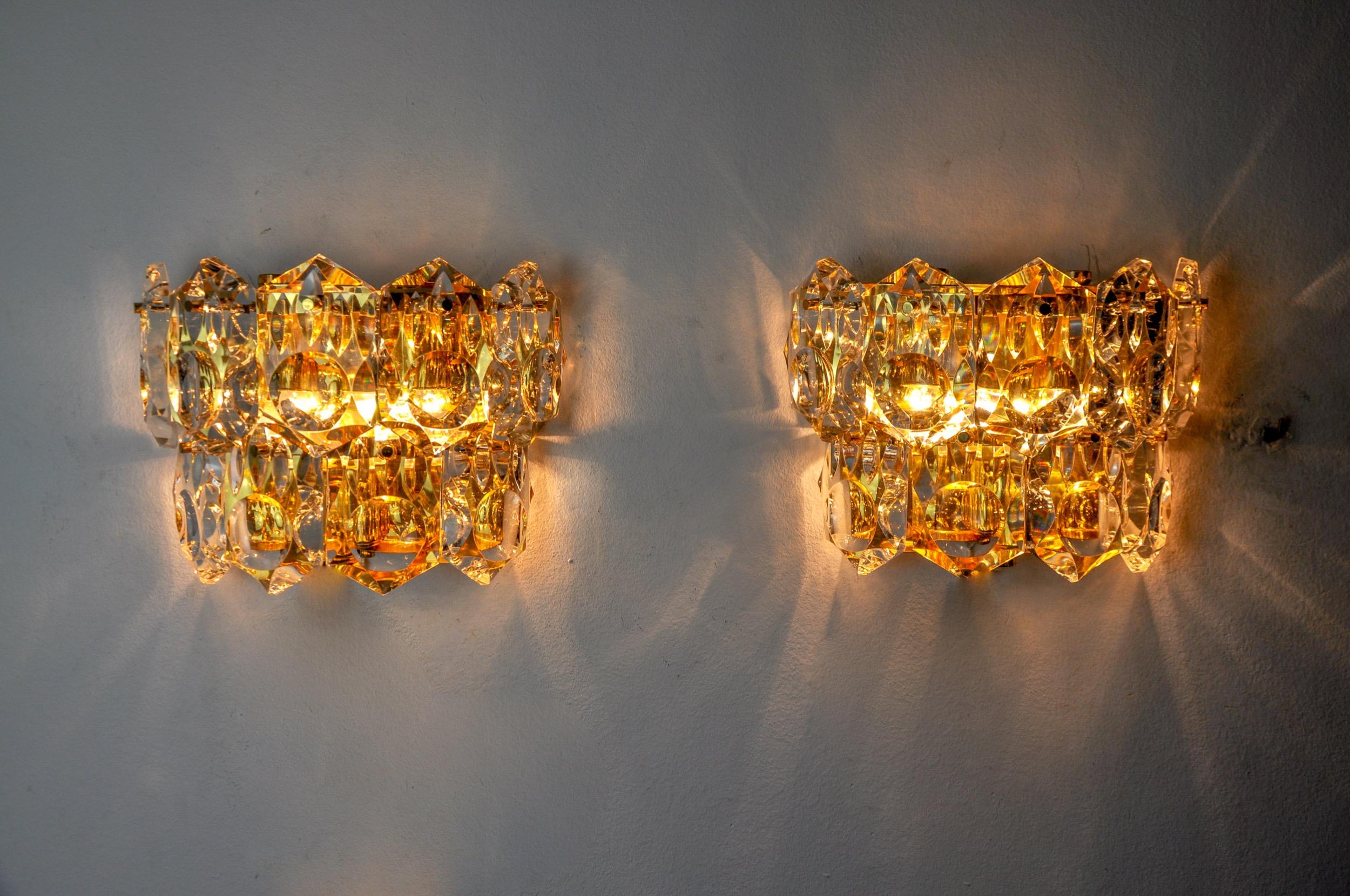 Sehr schönes und seltenes Paar Kinkeldey Wandleuchten, entworfen und hergestellt in Deutschland in den 1970er Jahren. Geschliffene Kristalle mit Vergrößerungseffekt, verteilt auf 2 Ebenen einer goldenen Metallstruktur. Ein seltenes Designobjekt, das