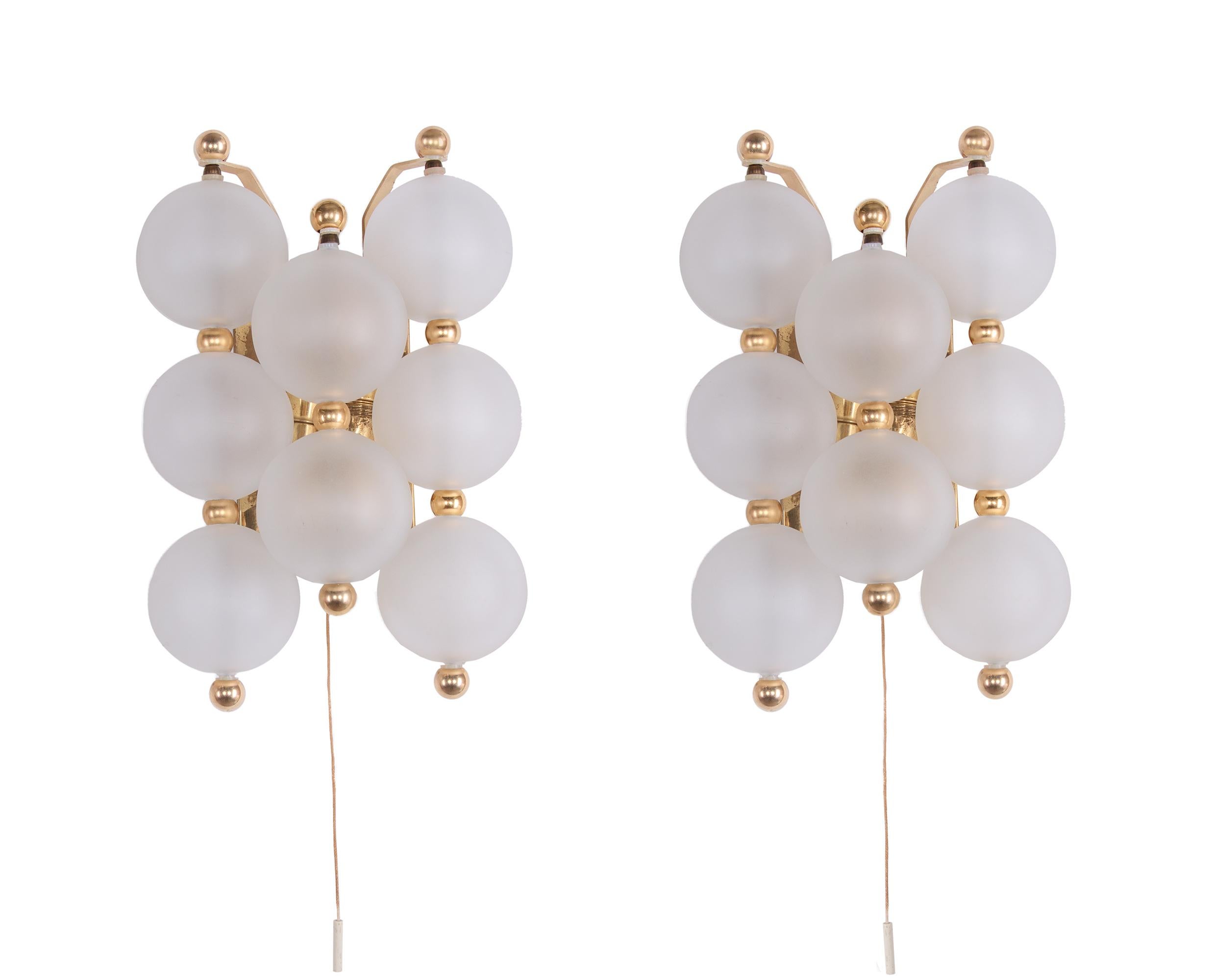 Elegant pair of wall lights with frosted glass balls with golden knobs on a brass frame. The lights illuminate beautifully. Gem from the time. A real eye-catcher even unlit. 

The matching chandelier is also in stock. 
 
Manufacturer: A. H.