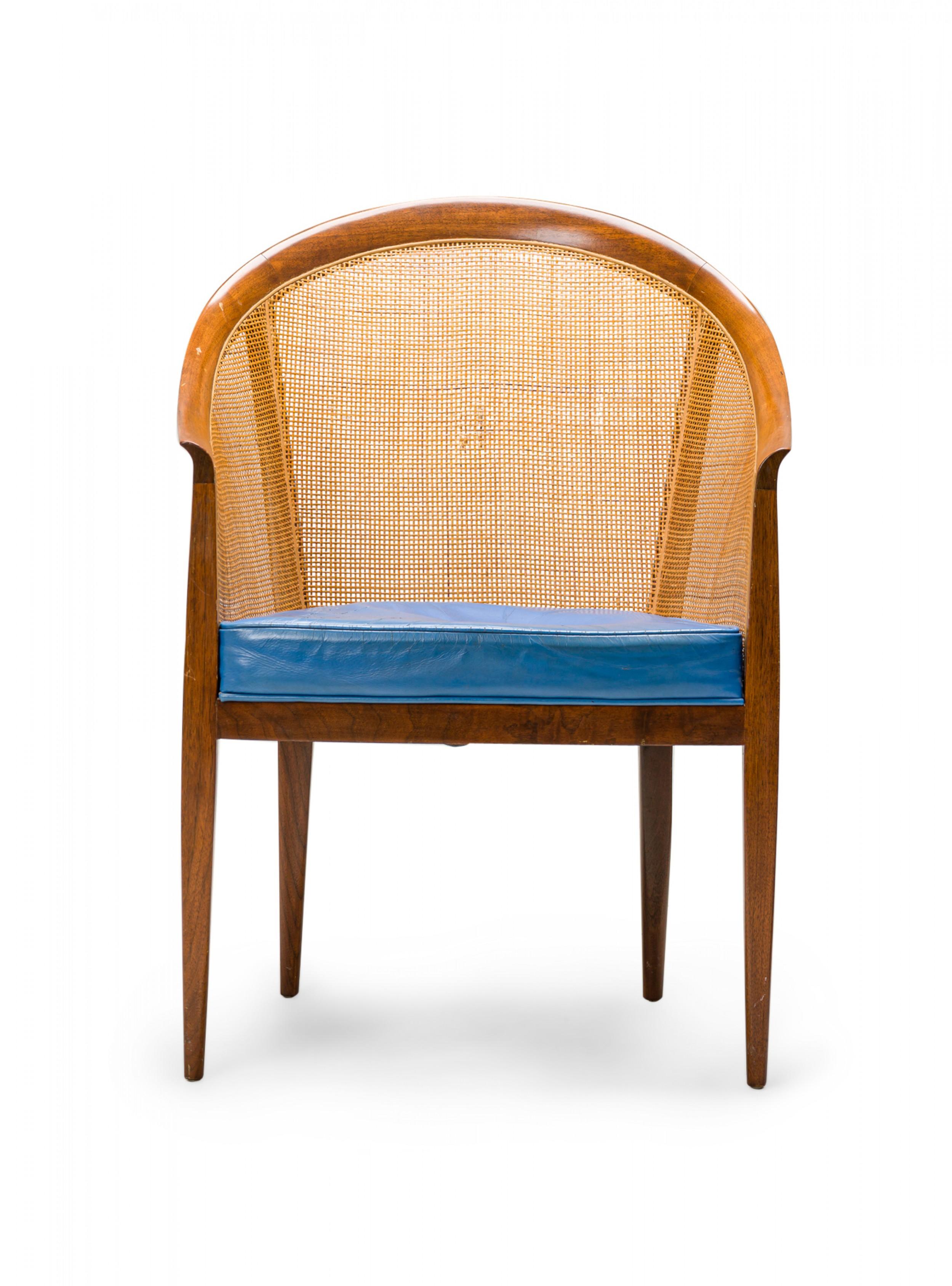 PAIR of American Mid-Century pull up chairs with rounded back walnut frames with caned backs and sides and blue leather seat cushions, resting on four tapered legs. (KIPP STEWART FOR DIRECTIONAL)(PRICED AS PAIR)
