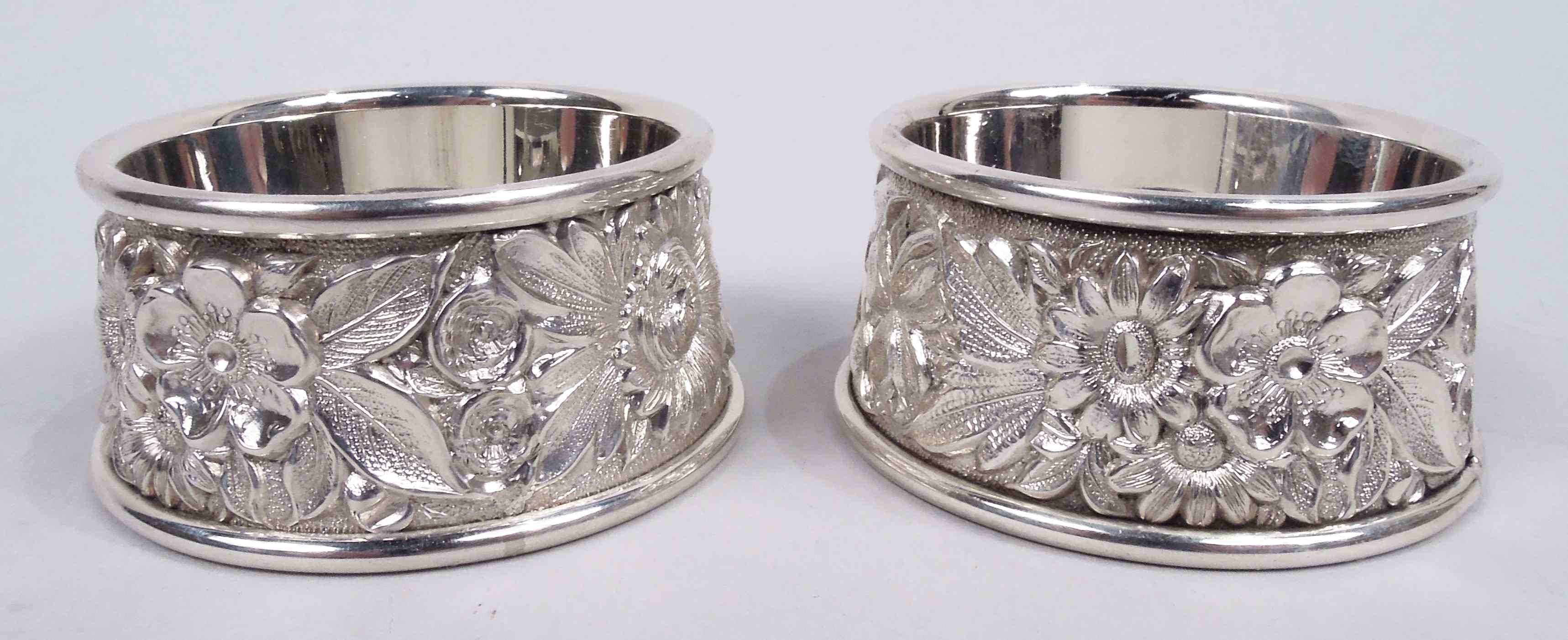 Pair of Edwardian sterling silver open salts. Made by S. Kirk Son Inc. in Baltimore. Each: Round and plain well set in upward tapering ring with repousse floral garland on stippled ground. Fully marked including maker’s stamp (1925-32) and no. 59. 