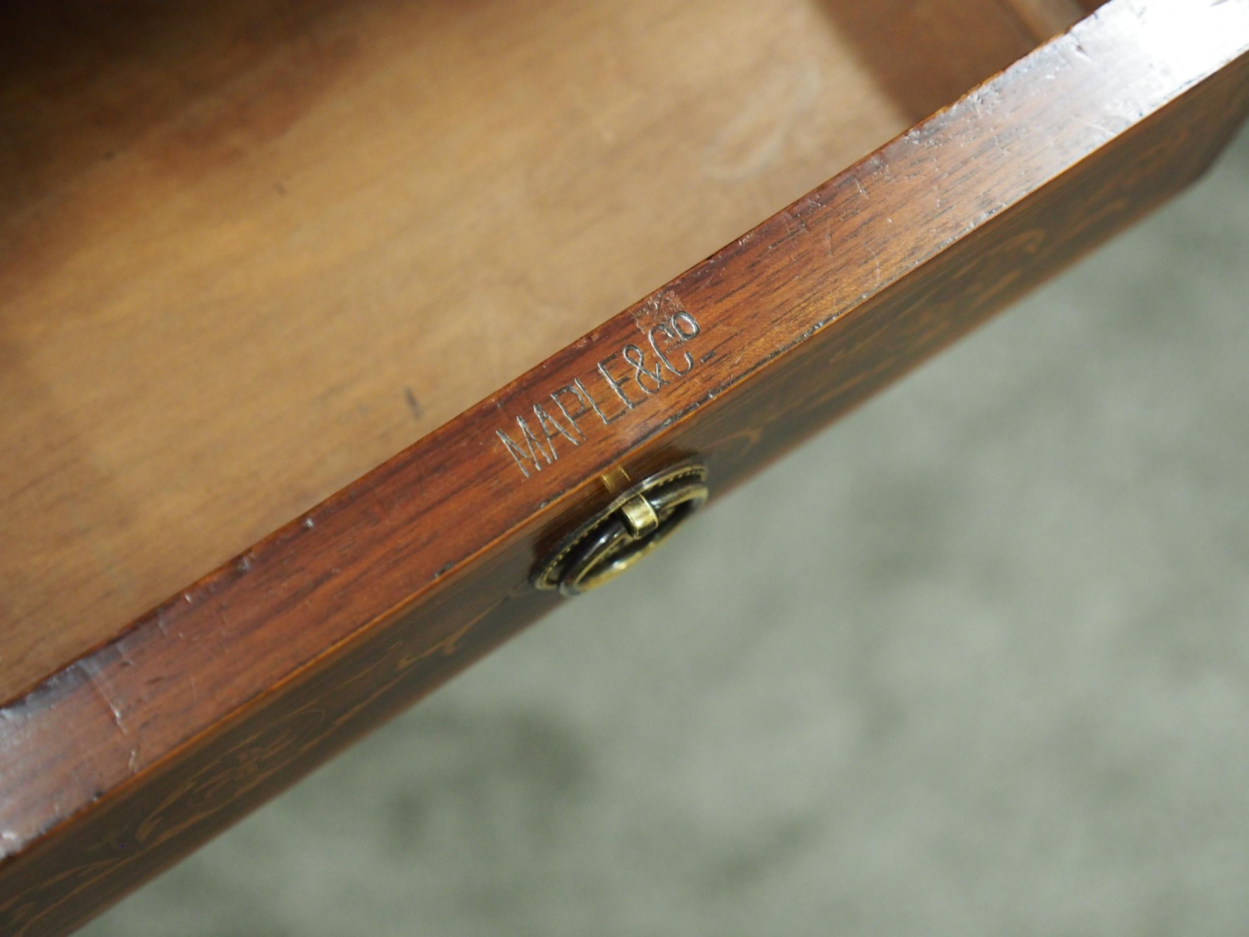 Pair of inlaid mahogany kneehole desks by Maple and Co. of London, circa 1890 with restorations. The inlaid rectangular tops have gilt-tooled burgundy writing surfaces and are above a central frieze drawer decorated with marquetry, satinwood inlay