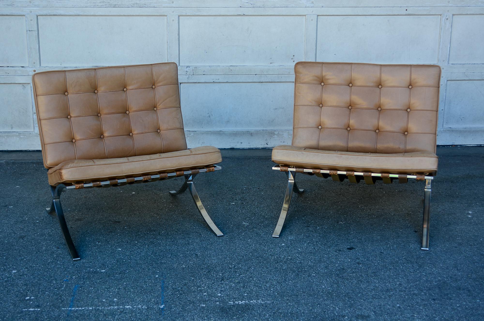Pair of Barcelona chairs manufactured by Knoll. These have a polished stainless steel frame with tan or saddle colored leather. These were purchased in the 1970's. The chair frames show some wear. The leather has a nice patina with no tears. There