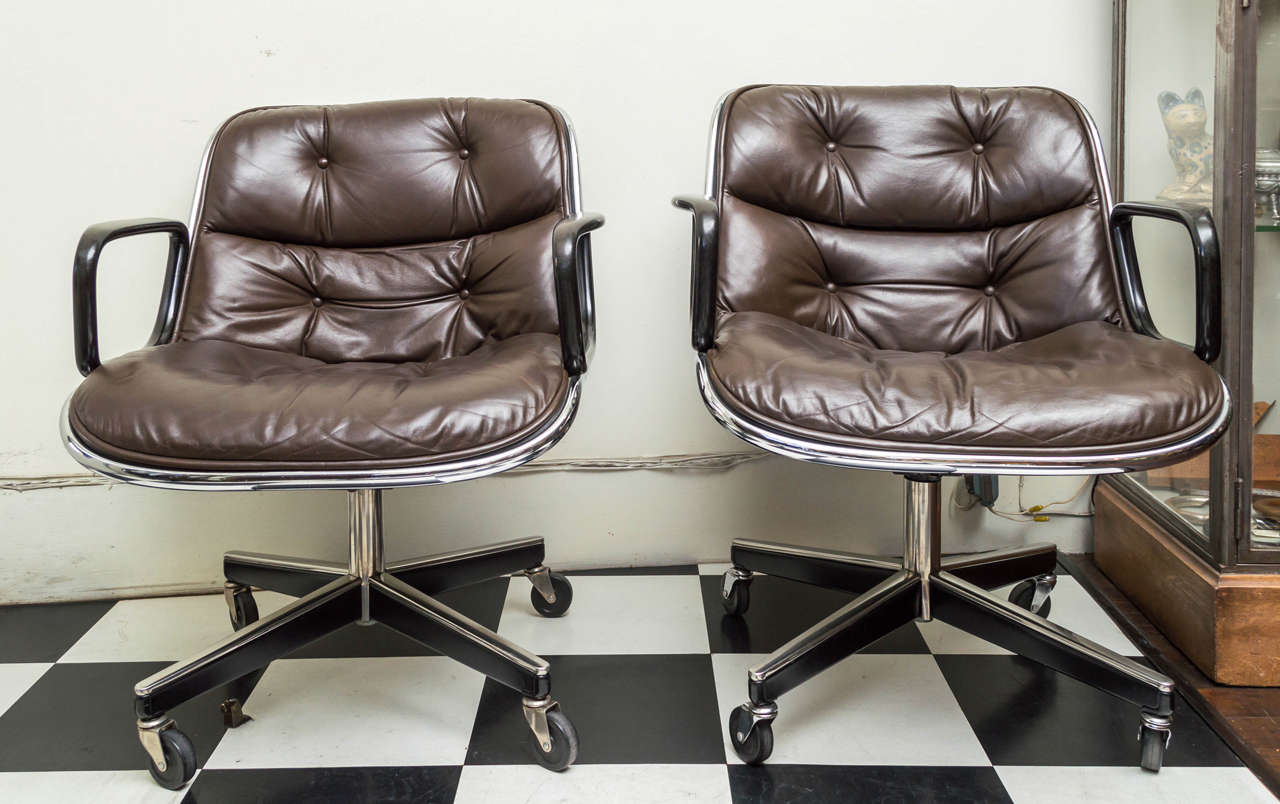 Pair of Knoll black leather Pollack Executive armchairs. Vinyl tub with seasoned leather button and tufted upholstery. Four legs on a stainless steel and metal base. Cast black resin arms. Designed by Charles Pollack for Knoll, 1963. In production