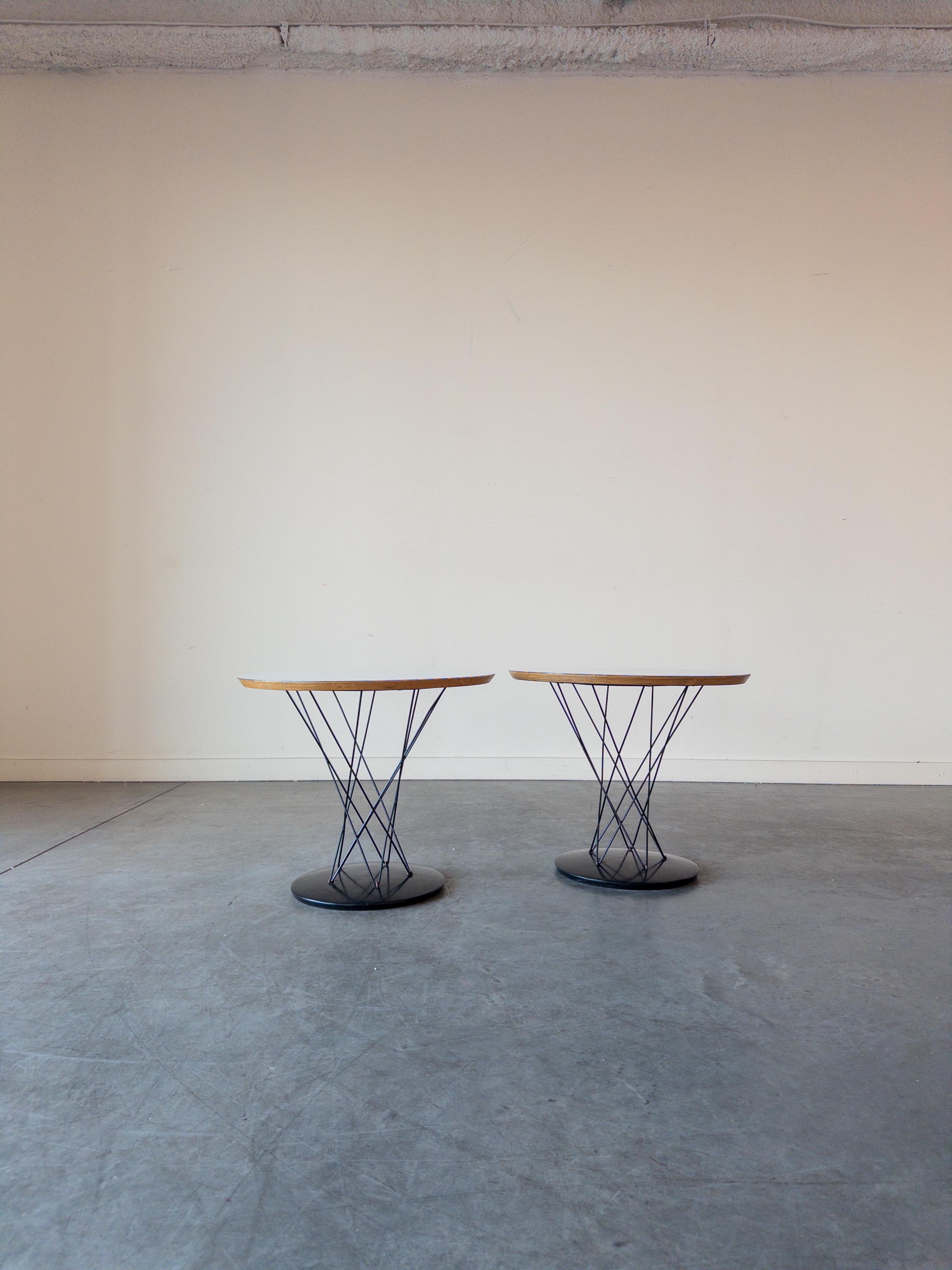 Pair of Knoll Cyclone Side Tables, Model 87 designed by Isamu Noguchi for Knoll. This example dates to the 1960s. The piece has a cast-iron base which is coated in black porcelain enamel and has a white laminate top. Both End tables retain the