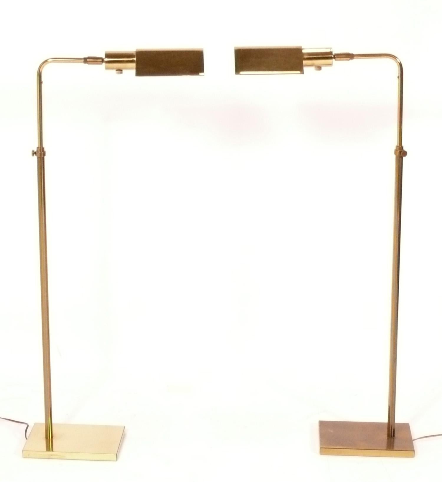 Pair of clean lined Mid-Century Modern pharmacy lamps, designed by Koch and Lowy, American, circa 1960s. They are adjustable in height, and they also swivel and tilt, making them the perfect reading lamps. They retain their warm original patina to