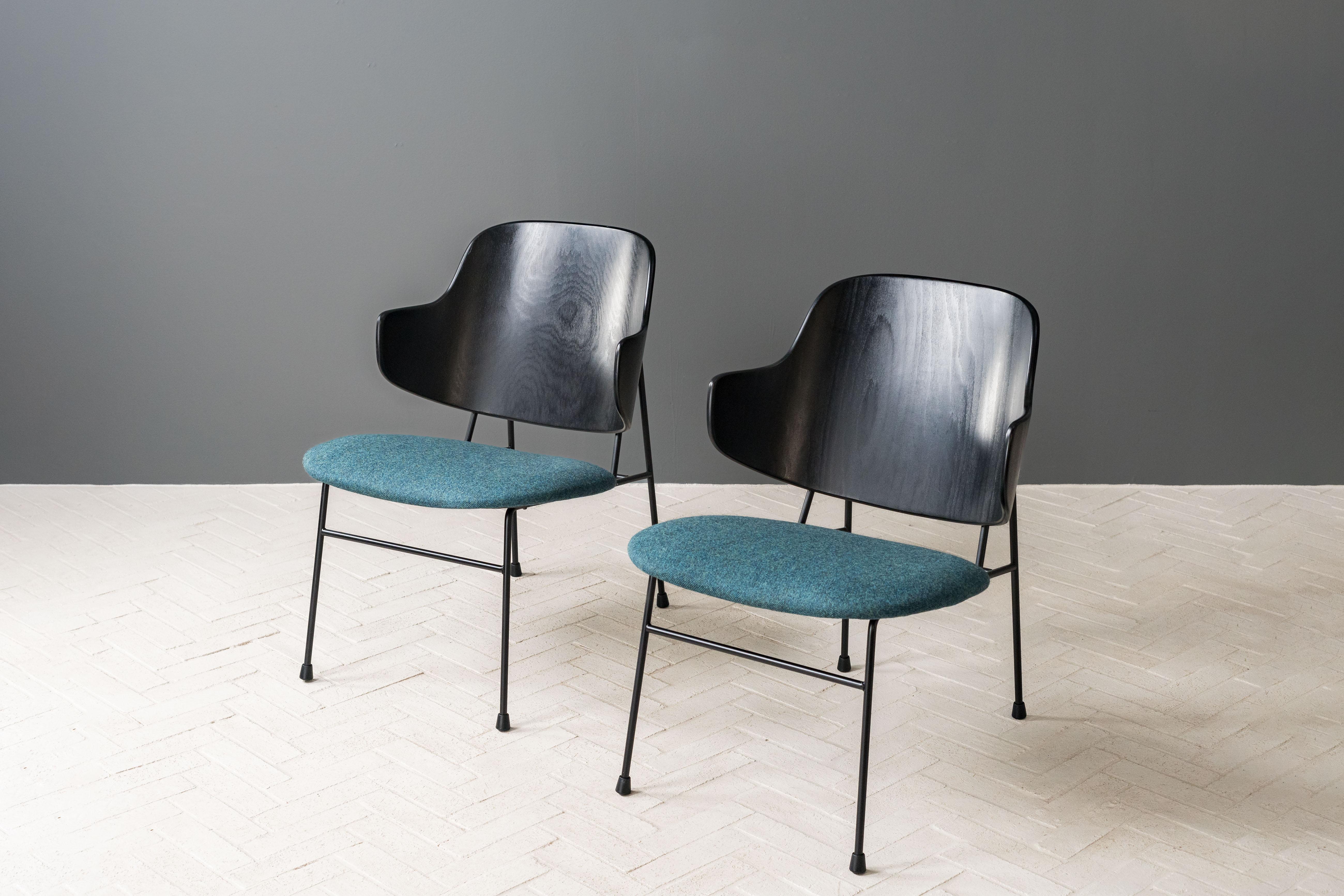 Denmark, ca. 1950s. An attractive pair of sculptural lounge chairs by Ib Kofod-Larsen for Leominster-based importer Selig. Each features sturdy wrought iron frame with playful yet comfortable curved, ebonized beech backrest. Plush seat freshly