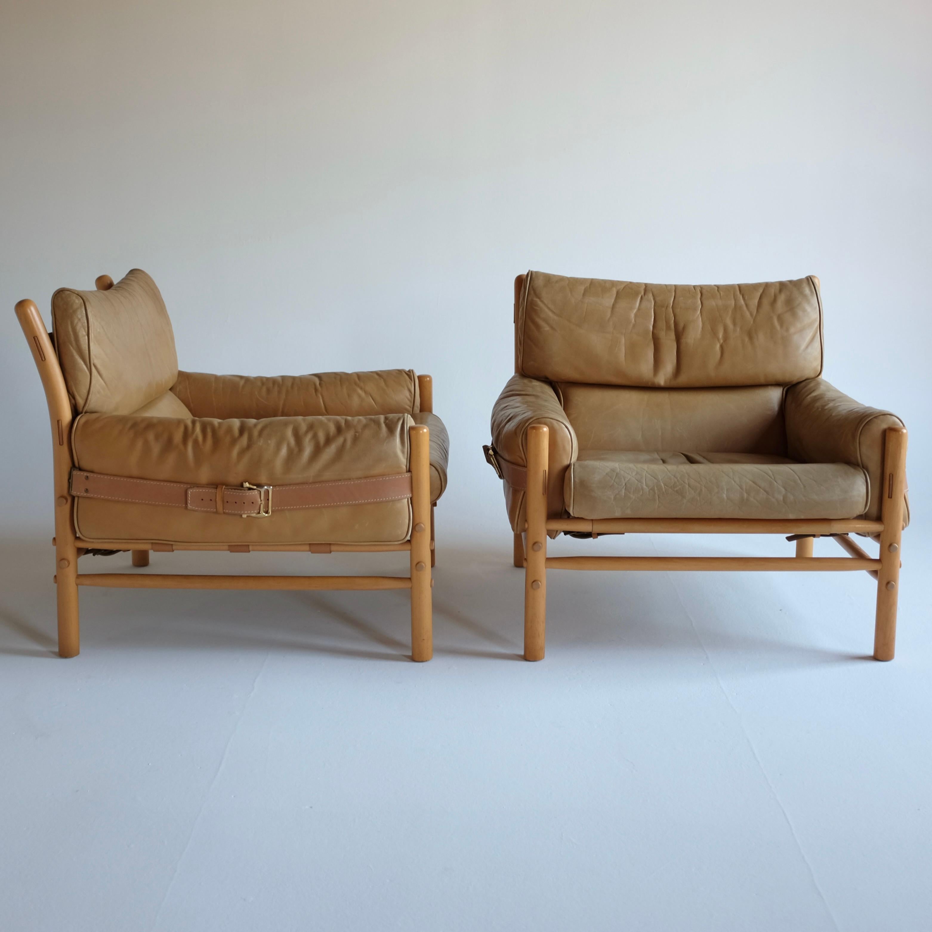 Pair of wood and leather Kontiki Chairs by Arne Norell for his namesake company in Sweden. Arne Norell designs are renowned for their comfort and ease, especially visible in these Kontiki lounge chairs. Decorative details with brass buckles and
