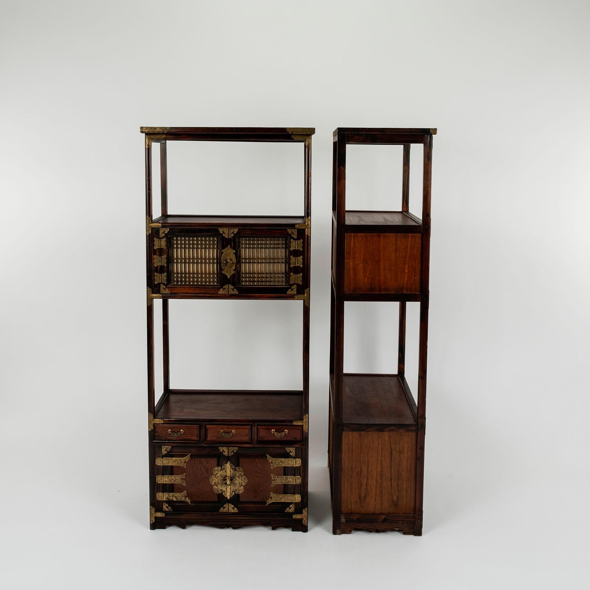 Pair early to mid 20th century Korean étagères with brass hardware. Each features four cabinet doors with 3 drawers.