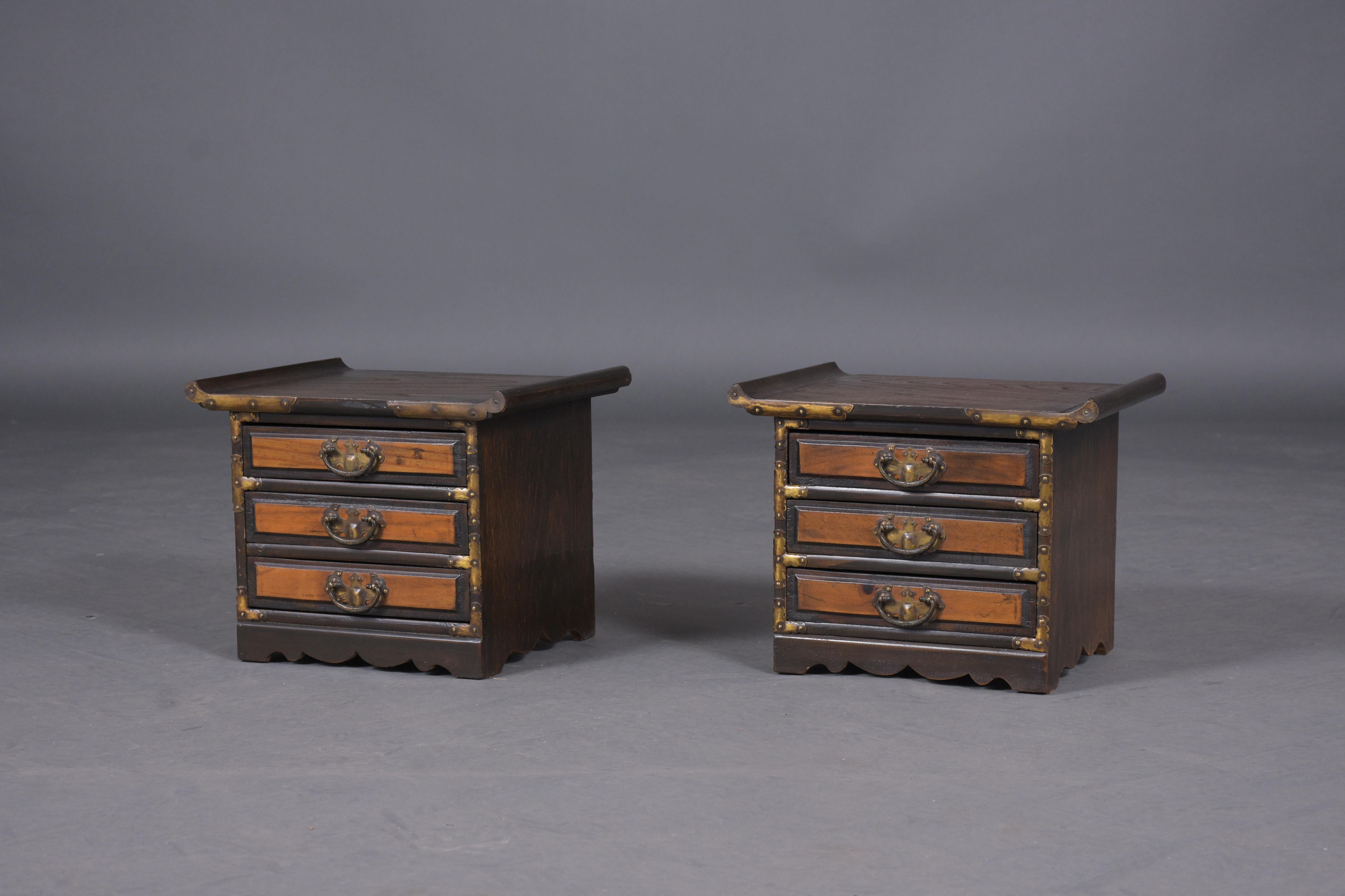 An extraordinary pair of tansu cabinets hand-crafted out of elmwood in good condition that has been professionally restored. This fabulous pair of cabinets feature a dark & light walnut stain finish that has been only waxed and polished developing a