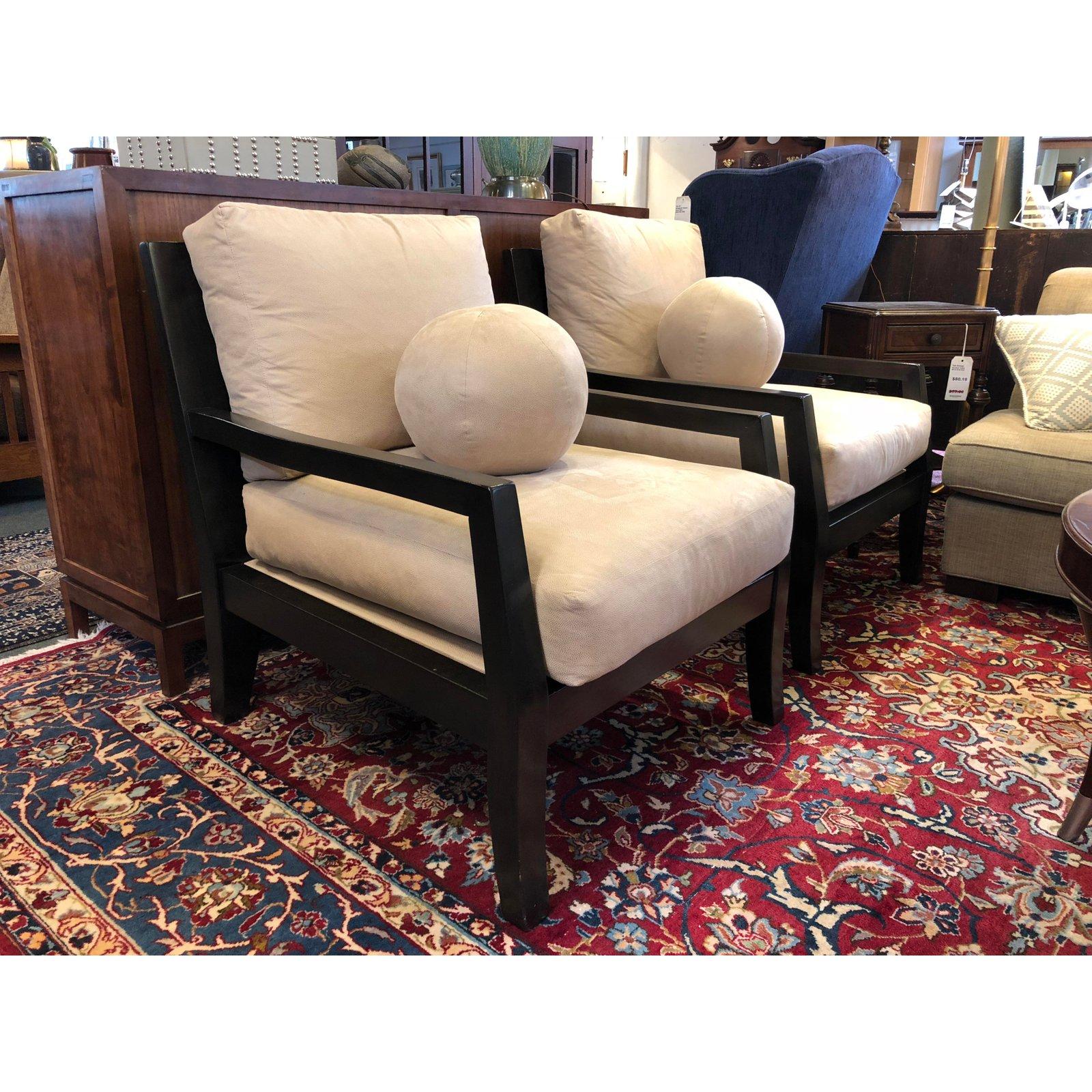 A comfortable pair of Kreiss lounge chairs. The slotbacks could give a tropical touch to a modern look. The artful combination of dark hardwoods and textured ivory suede keeps the pair neutral.
 