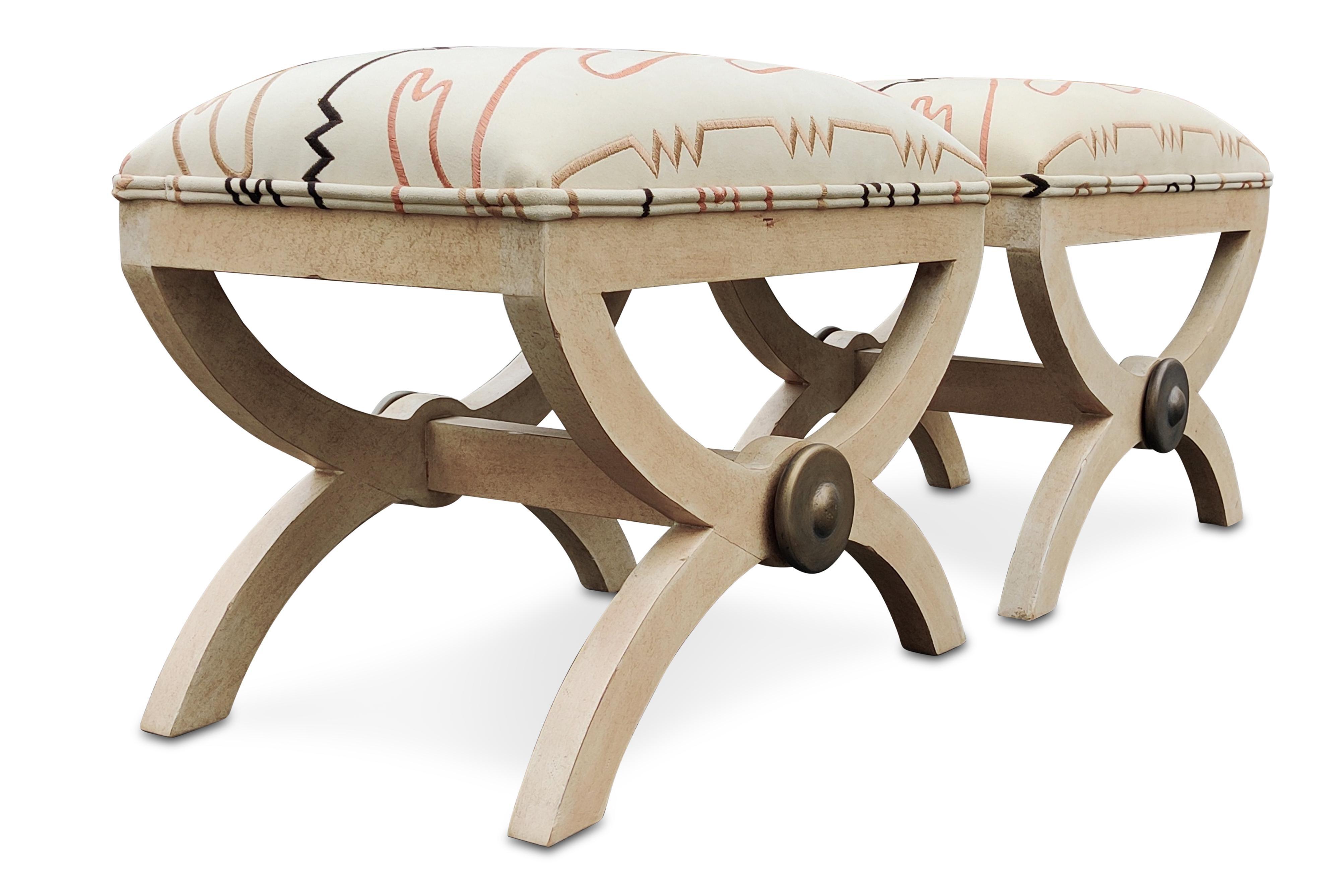 This pair of benches are manufactured by luxury company Kreiss, who commissioned these as a part of their Kreiss Collection, meaning they were designed in-house. They feature a carved and lightly colored wood base composed of two inverted