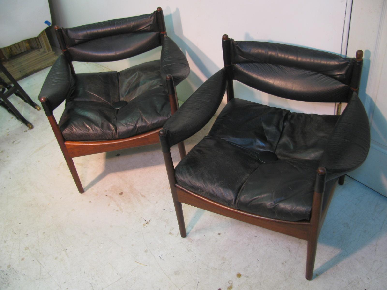 Beautiful pair of rosewood and black leather lounge chairs by Kristian Vedel. Leather sling arms with a drop in leather cushion. Elegant rosewood frames with arched curves and turned leg posts.