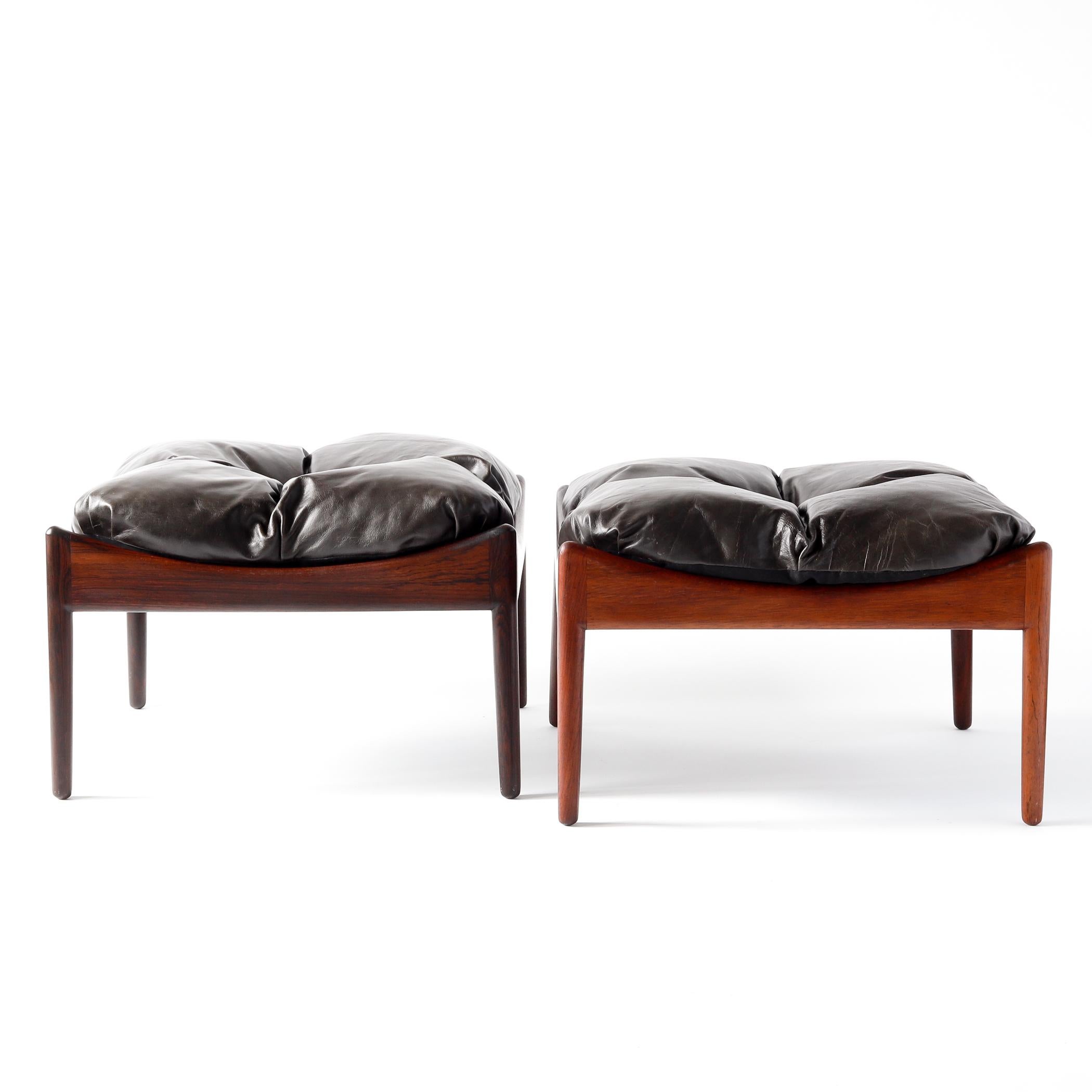Pair of Danish Modern rosewood ottomans or stools with leather cushions designed by Kristian Vedel for Soren Willadsen of Denmark. These ottomans were part of Vedel's Modus line from the 1960s, which included a lounge chair and side table that used