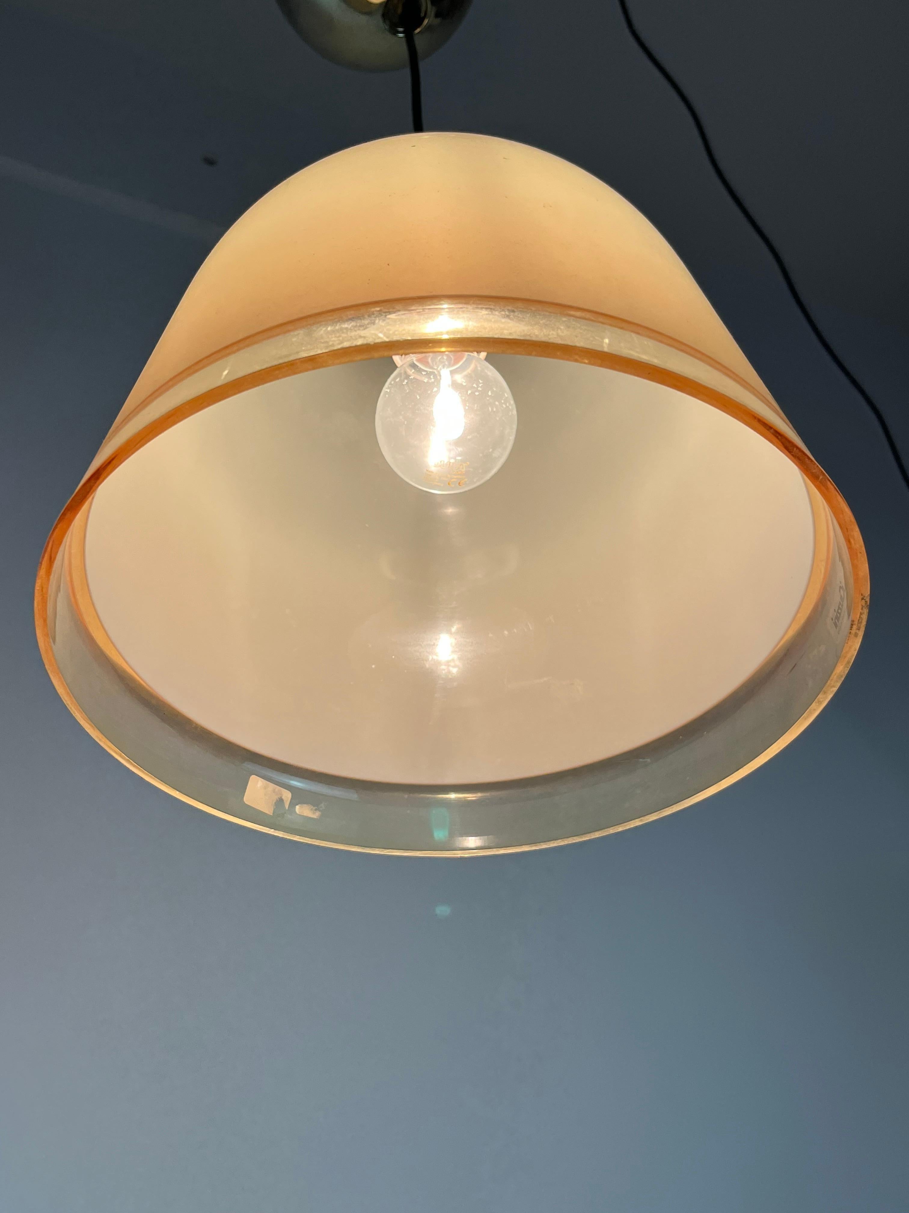 Pair of Kuala model chandeliers, designed by Franco Bresciani and produced by iGuzzini, 1975.
Bell-shaped conical lampshade, made of ocher-colored translucent acrylic. It has a chromed metal sphere, gold color, on the top of the lampshade. Attack E