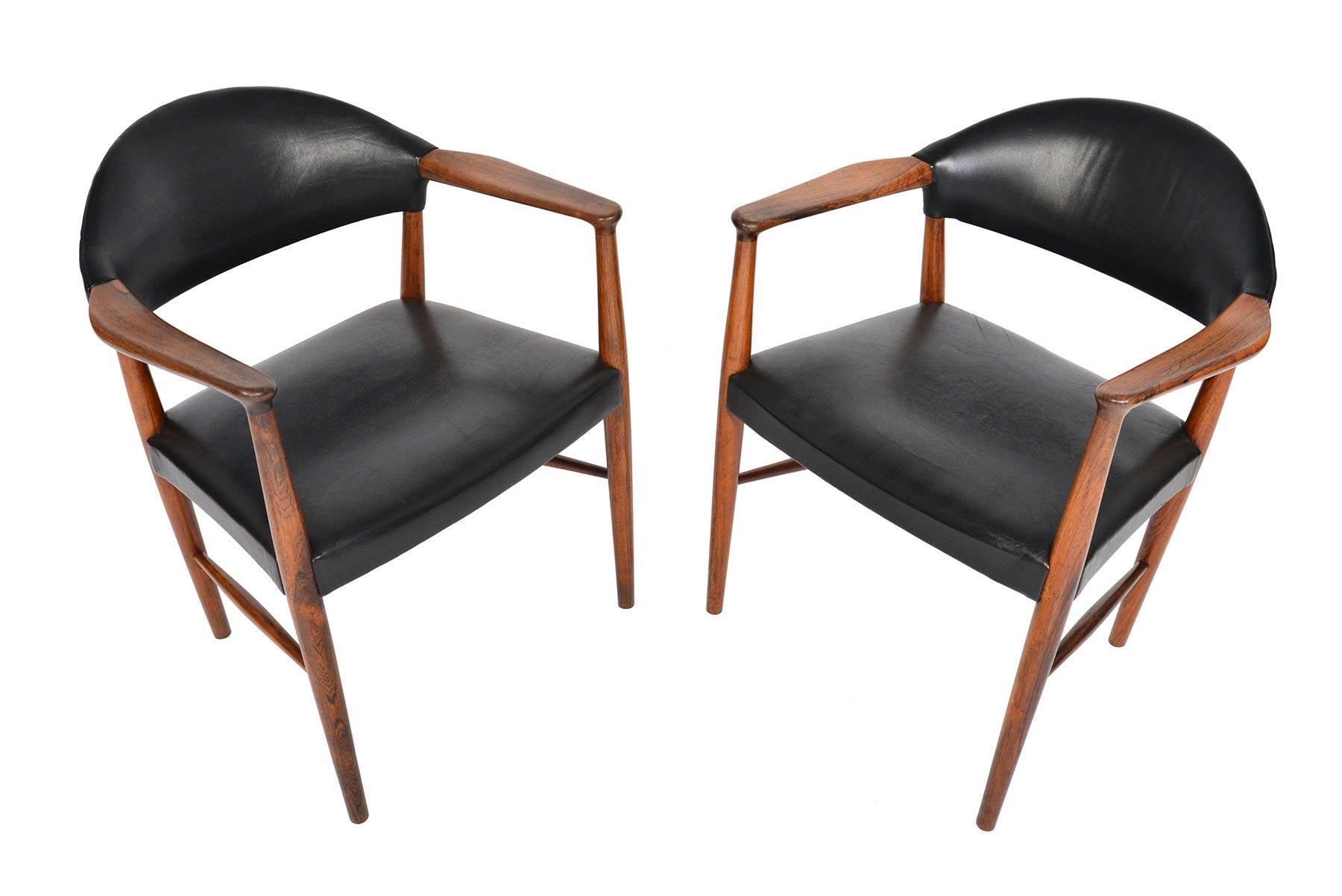 Designed by Kurt Olsen for Slagelse Møbelværk in 1955, this pair of armchairs model 223 offer a design that is both timeless and modern. Crafted in beautiful Brazilian rosewood, chairs wear their original patinated black leather covers. Originally