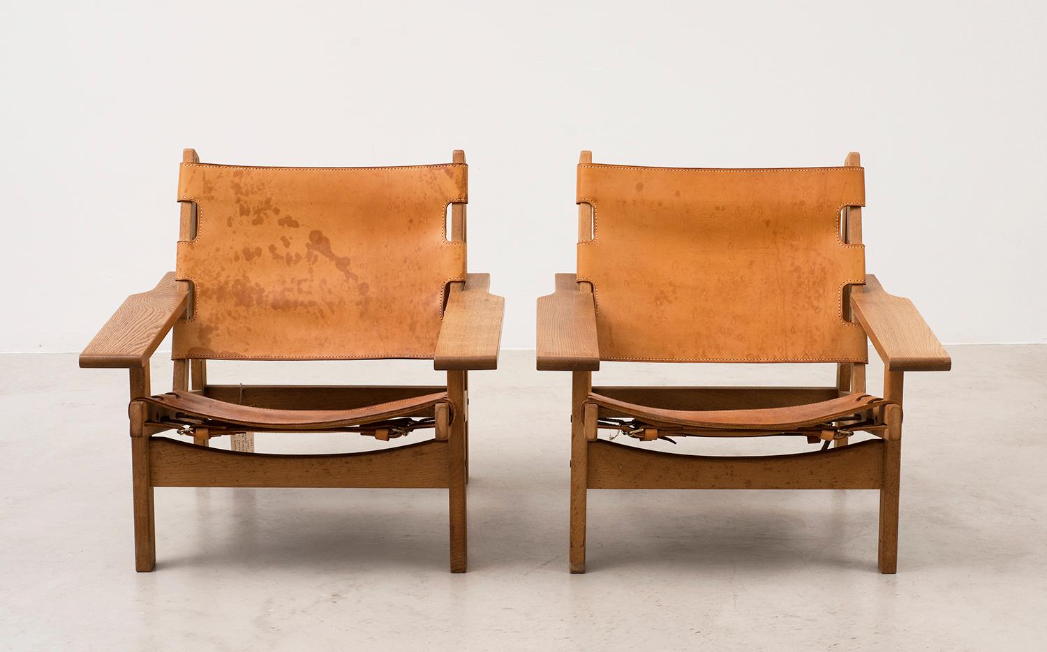 A pair of solid oak easy chairs, seat and back with patinated natural leather by Kurt Ostervig. Manufactured by K. P. Jørgensens Møbler, Denmark, 1960s.