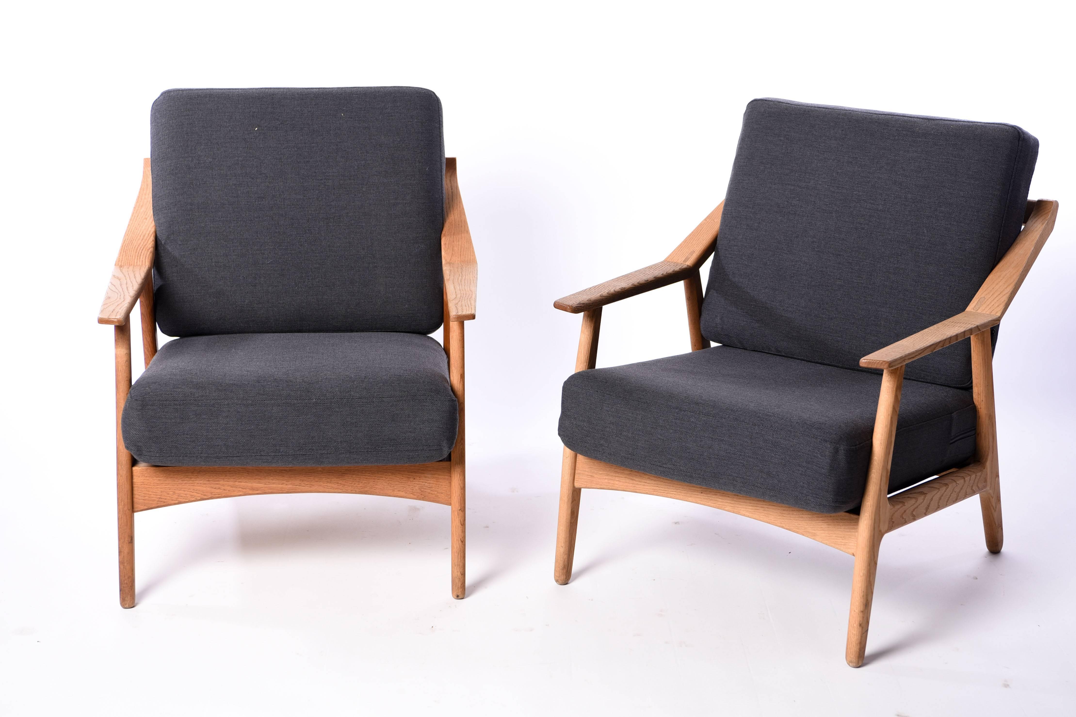 This is a fabulous pair of easy chairs designed by Kurt Ostervig. They feature oak frames and have been newly upholstered in a lovely gray color that juxtaposes well against the lighter wood. A great example of Danish design, circa 1950s.