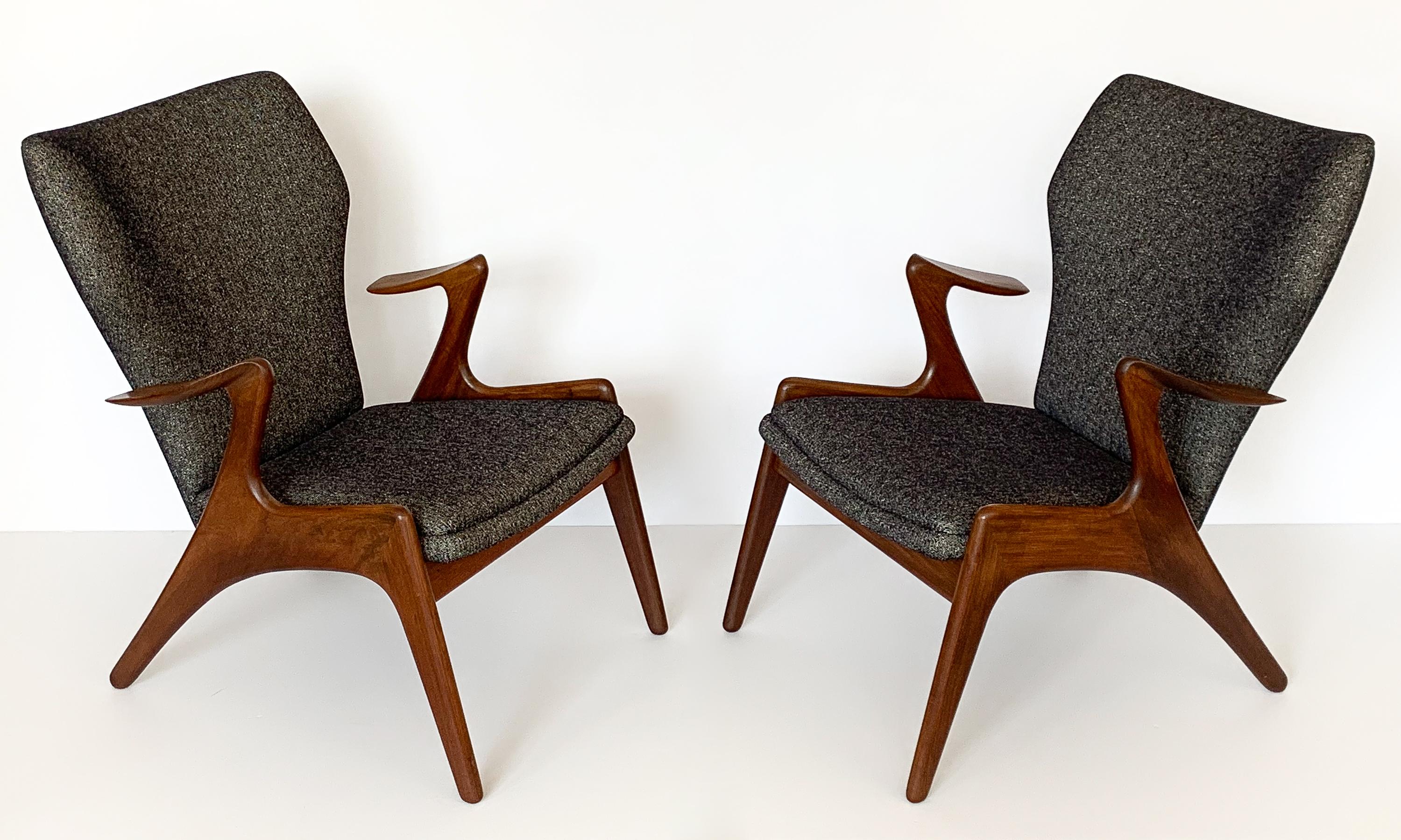 An exceptional pair of Danish sculptural teak lounge chairs by Kurt Ostervig, circa 1960s. Solid teak construction with angled back legs and sculpted leaf shaped floating armrests. Teak has a darker color almost resembling walnut. Newly upholstered