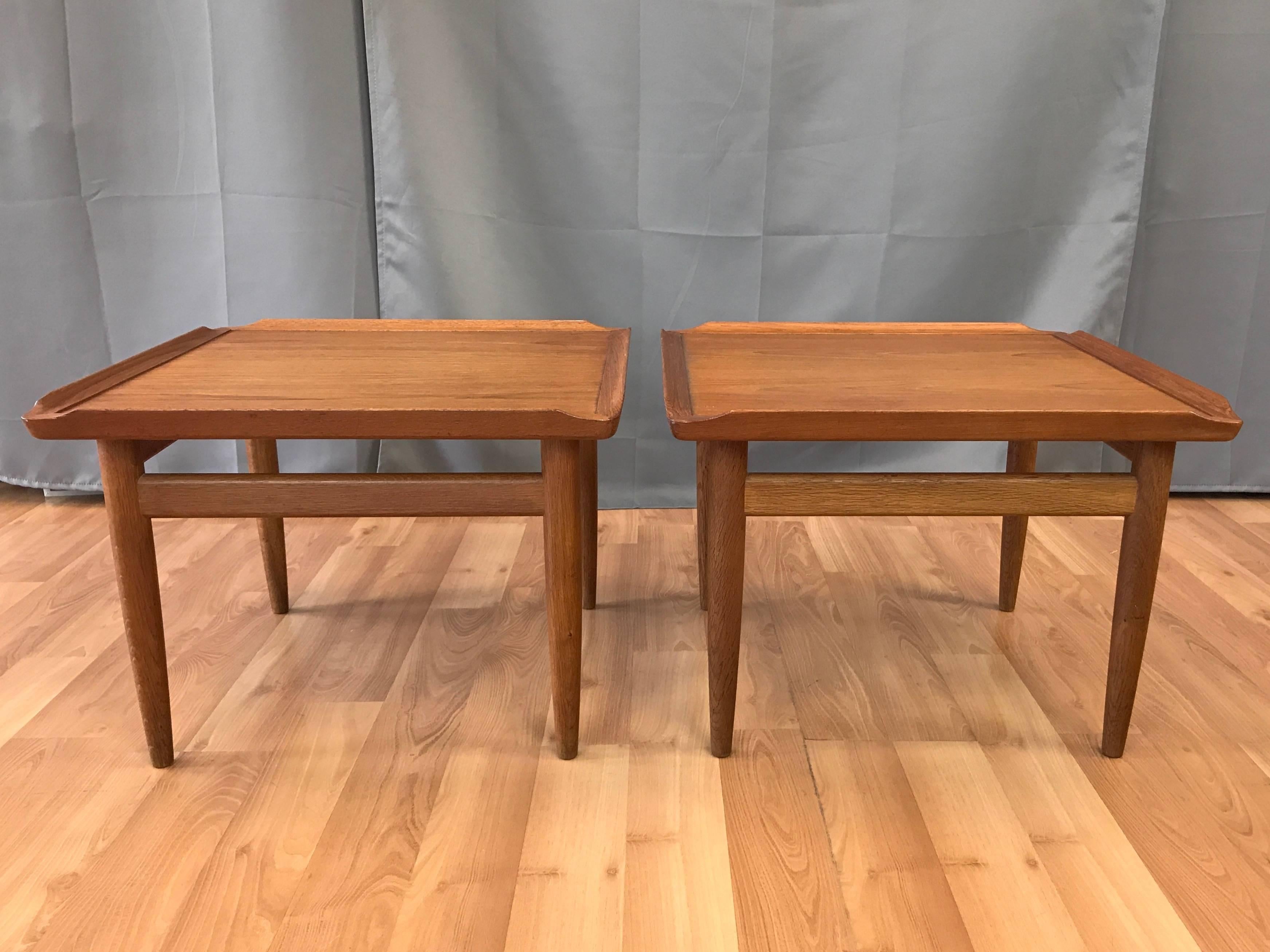 A rare pair of 1950s Danish teak and oak side or end tables by Kurt Østervig for Jason Møbler.

Square teak top with handsomely figured bookmatched grain framed by a smoothly sculpted solid teak angled lip. On solid oak base and legs that have a