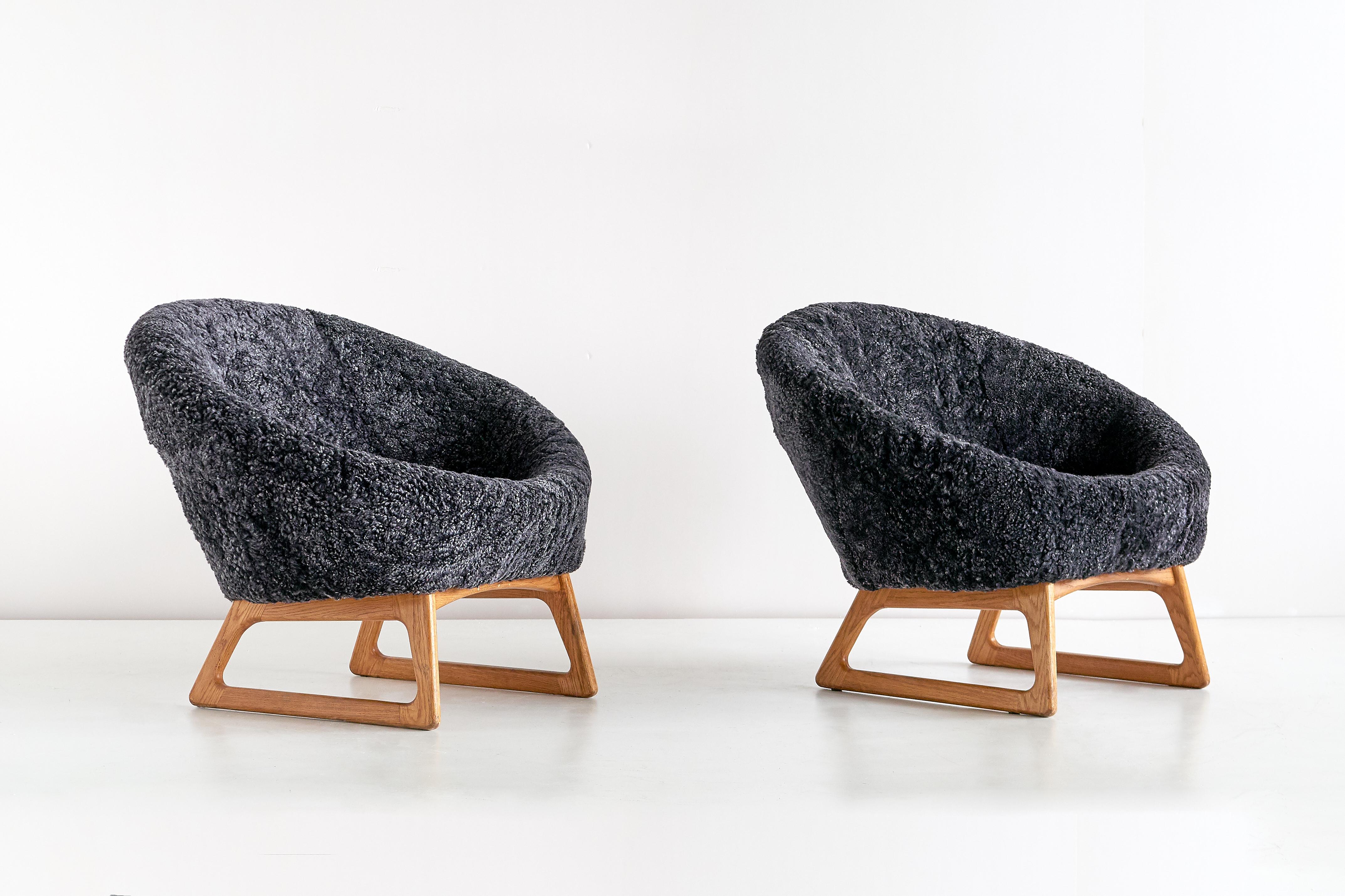 This pair of rare lounge chairs was designed by Kurt Østervig and produced by the Danish manufacturer Rolschau Møbler in 1958. The design is characterized by the round seat shell, mounted on a striking sled like base in stained oak.
The chairs have