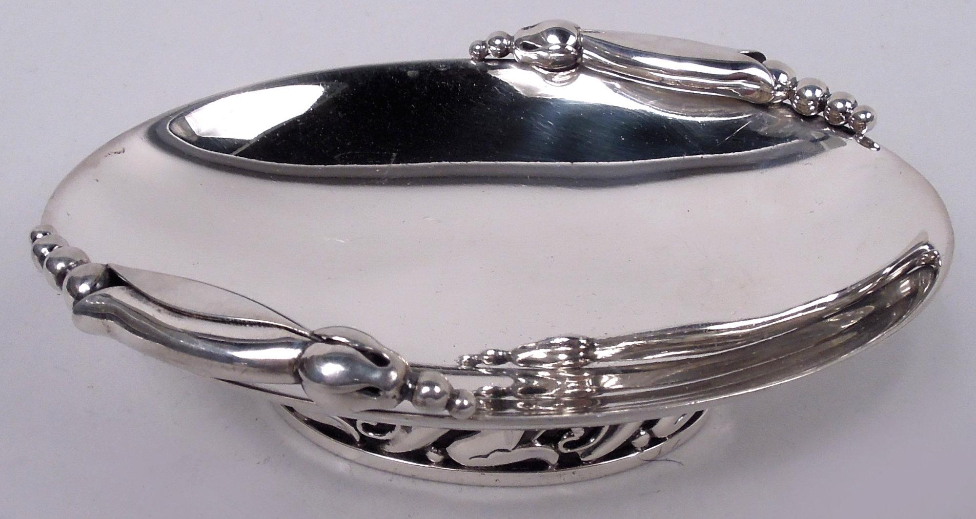 Pair of Midcentury Modern sterling silver nut dishes. Made by Alphonse La Paglia (d. 1953). Each: Shallow and curved oval bowl applied with seed-spilling pod in style of Jensen Blossom pattern. Open foot with stylized floral rinceaux. Fully marked