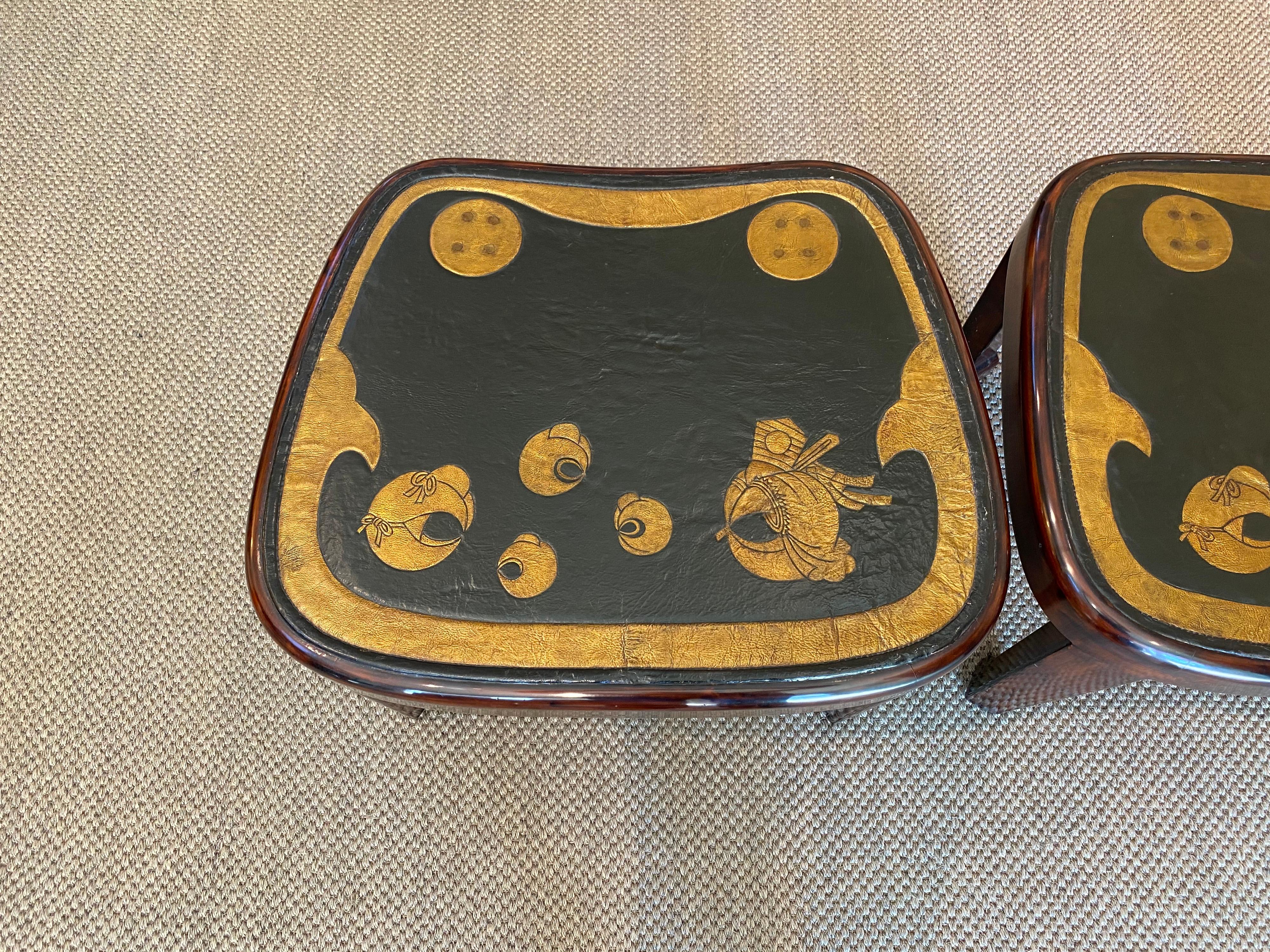 A pair of elegant and unusual side tables or coffee tables made by Gracie. 

The legs and apron were finished in cashew lacquer to fit the leather tops, which are antique pieces of leather. These leather pieces were part of a samurai's horse