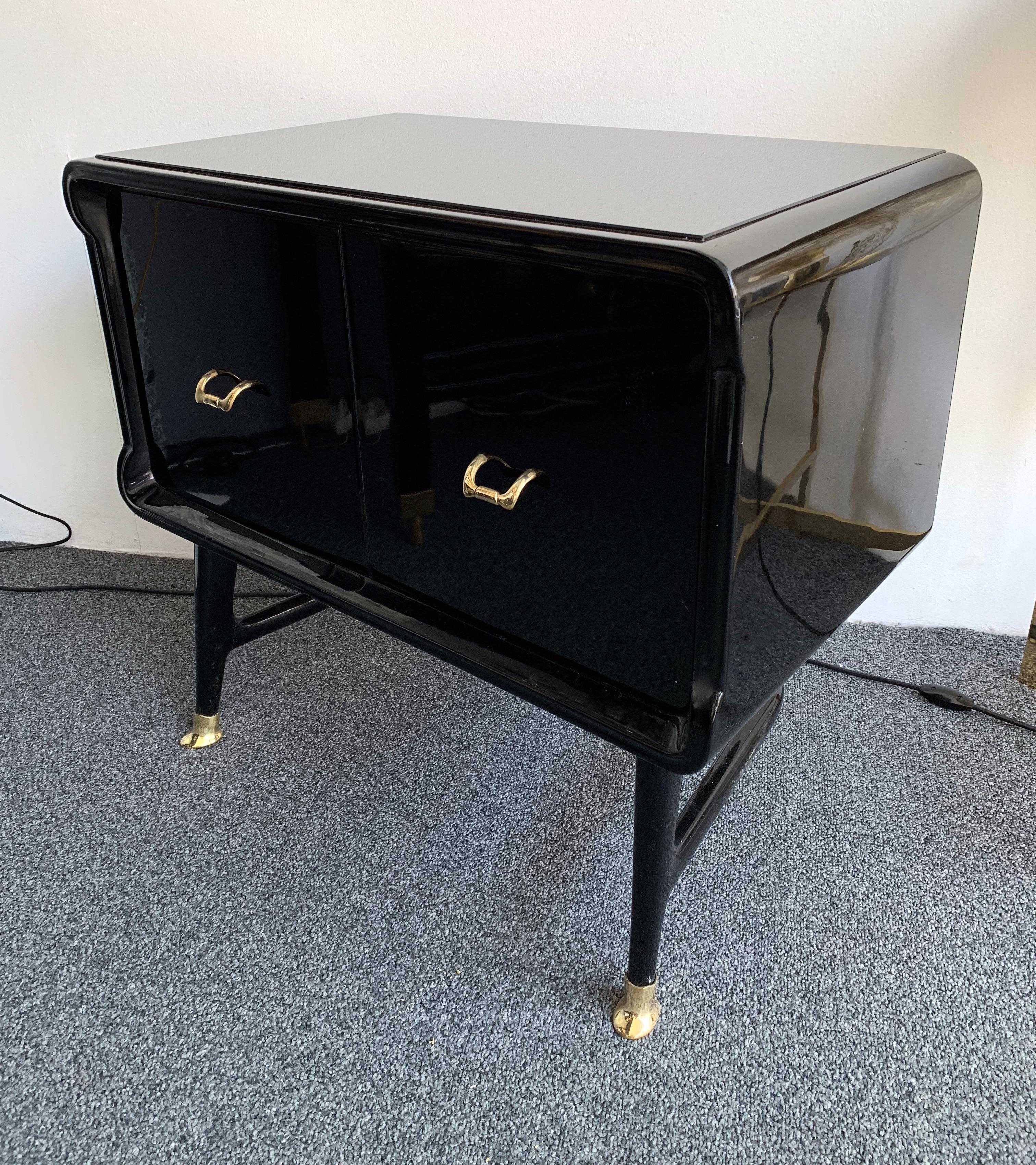 Pair of black lacquered wood nightstands, side end low tables, brass feet and handle, typical feet by the Italian designer Vittorio Dassi. Black opaline glass top. also available the sideboard buffet credenza or large commode chest of drawers.