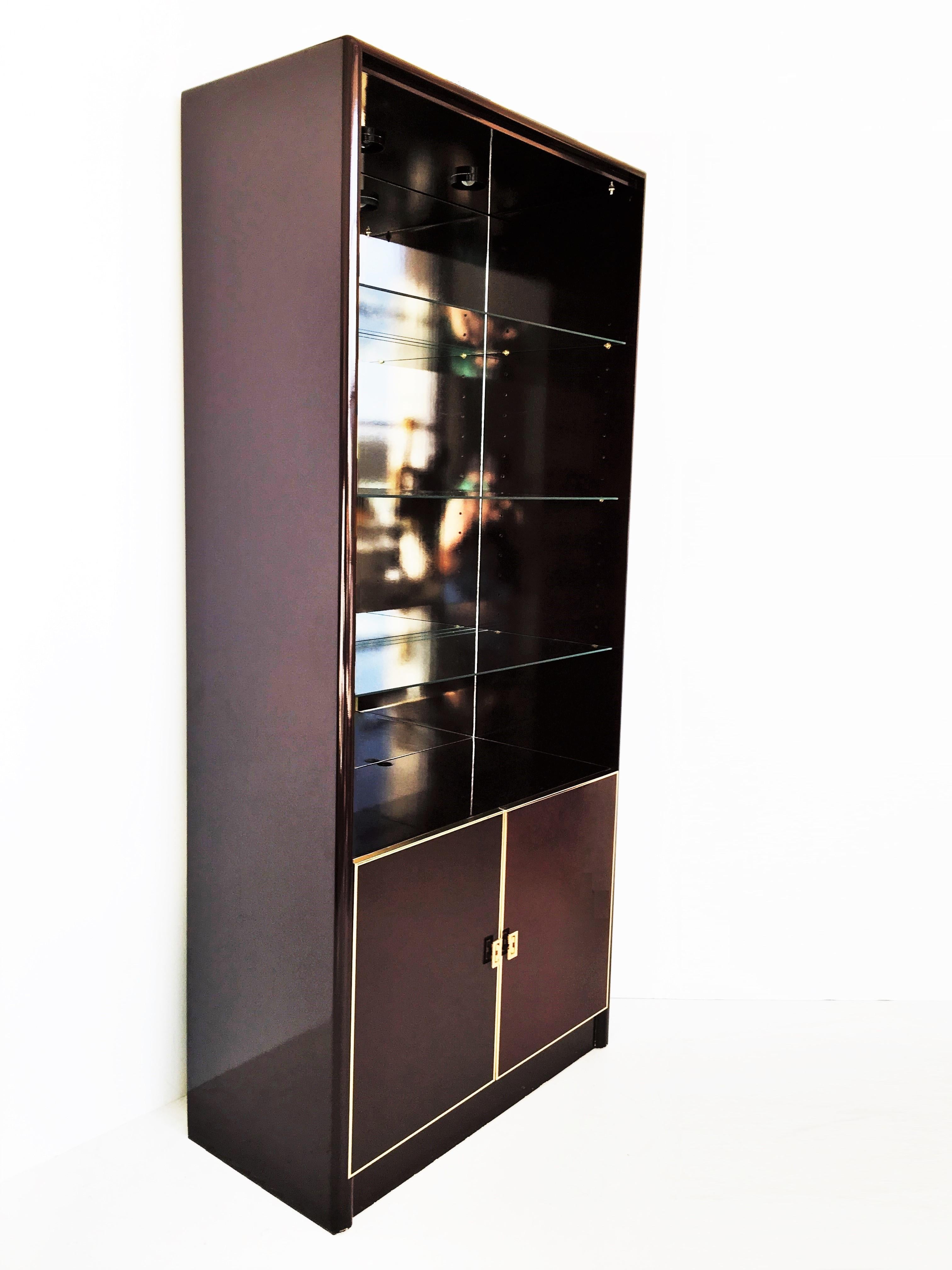 Absolutely amazing pair of lacquered china cabinets vitrines bookcases by Maison Jansen. With great attention to details for all the bronze inlays and edges. Features a lower double door case supporting a vitrine shelved cabinet, three adjustable