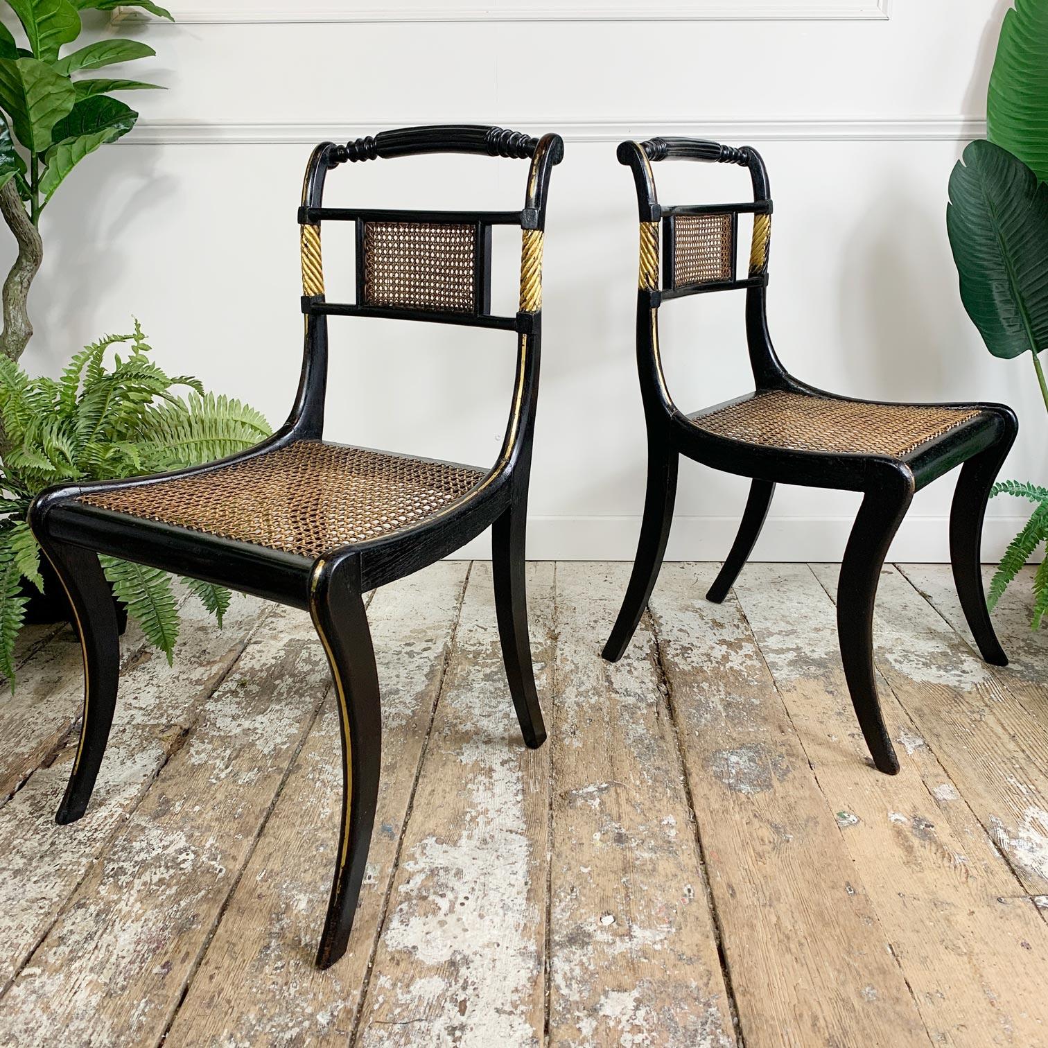 A stunning pair of Egyptian revival Regency chairs, circa 1820. The seats have been professionally re-caned, the central cane panels on the backrest are original. Wonderfully shaped and turned top rails compliment the sweeping formed legs, these are