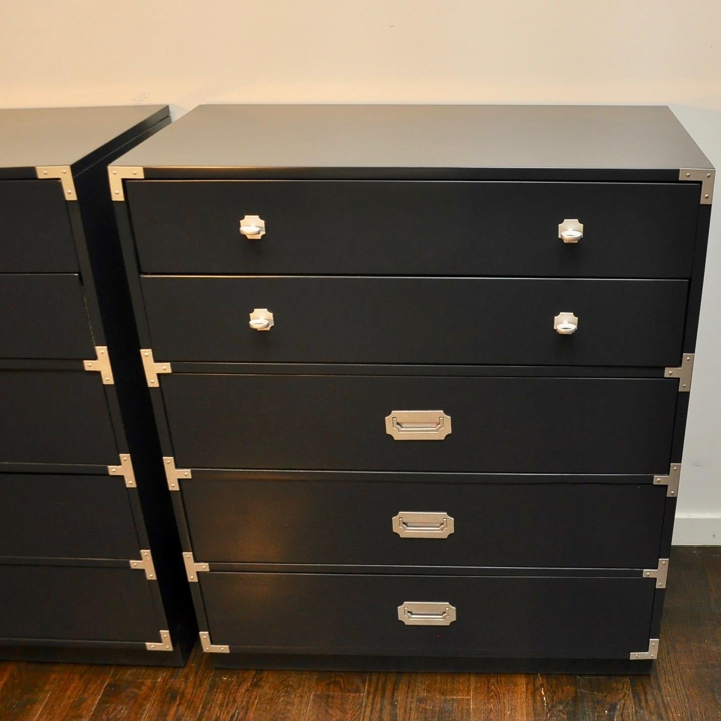Clean vintage par of campaign style dressers by Berhardt that have been re-invented with a lacquered refinish in a satin Raccoon Fur. Metal ornamentation is a metallic silver.