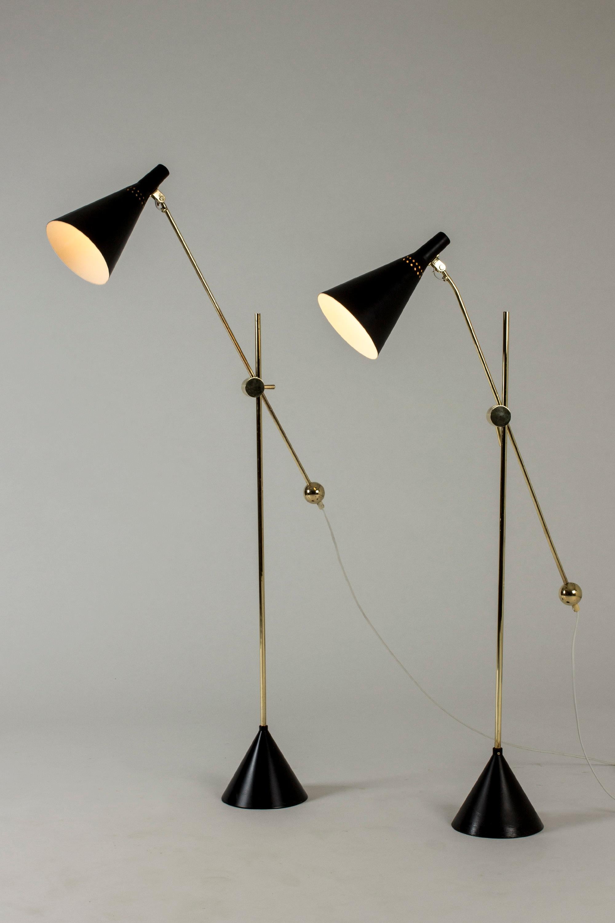 Pair of rare, amazing floor lamps by Tapio Wirkkala, made from brass and black lacquered metal. Beautiful decorative brass details and clever mechanism for shifting the height and angle of the shades. Conical bases.