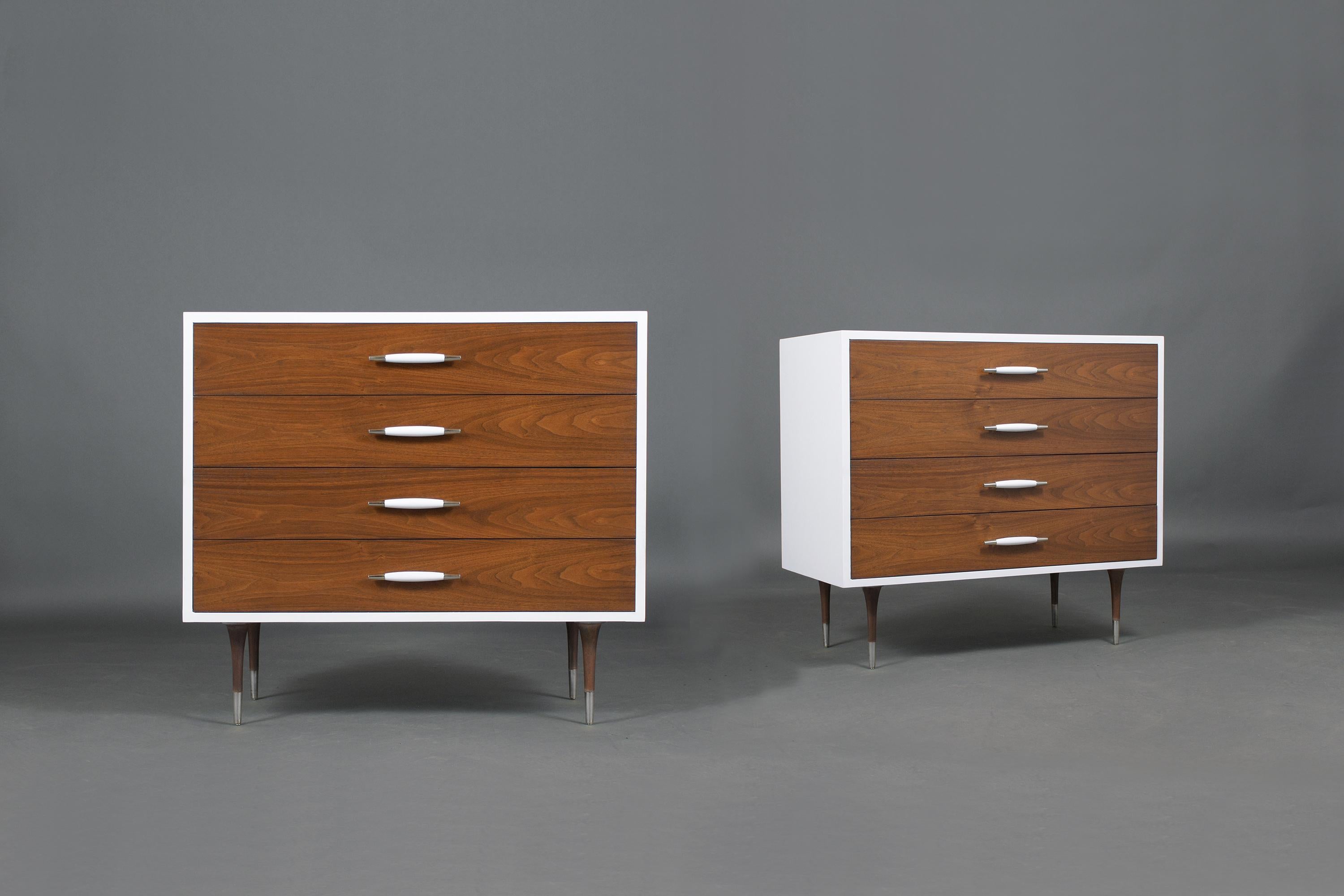 An extraordinary 1960s pair of mid-century dressers crafted out of wood professionally restored by our craftsmen. These pieces feature a new eye-catching white and walnut color combination with a lacquered finish. This fabulous vintage set of chests