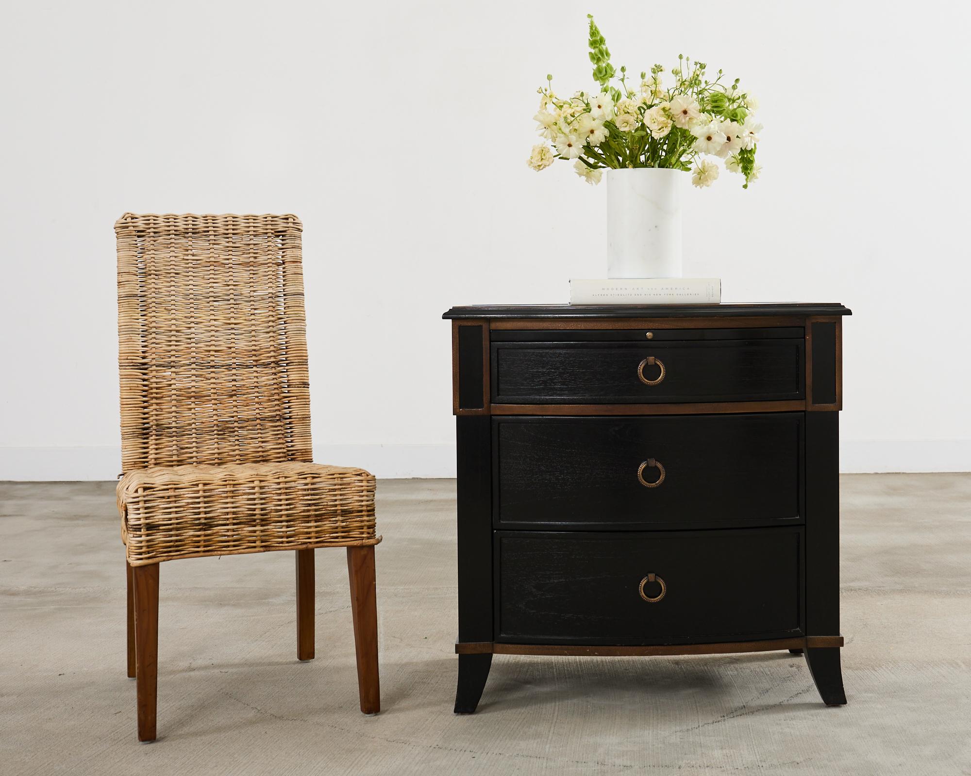 Paire de tables de nuit ou commodes à trois tiroirs, laquées noir, avec des tables d'écriture extractibles. Les coffres ont un panneau supérieur arqué avec un bord décoratif en ogee. Chaque coffret comporte trois grands tiroirs de rangement avec des