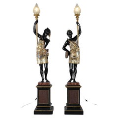 Pair of lacquered wood torchholders depicting Nubians