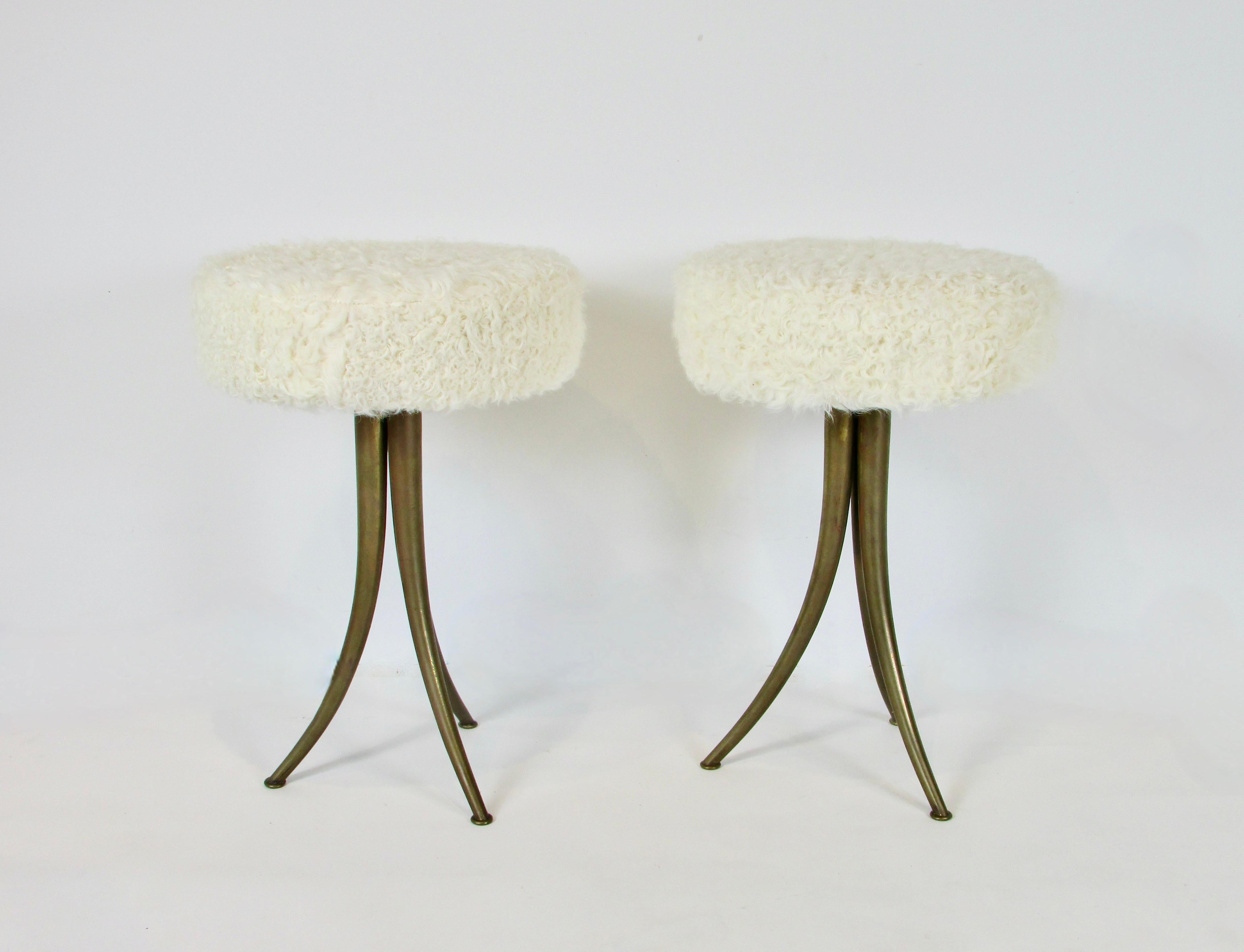 Pair of petite stools marked Made in Italy . Three legged stool with each leg tapering down to nickel size glides on the floor . Sensually curved tapering legs support Lambskin covered cushions . One stool retains water decal label . Seats have been