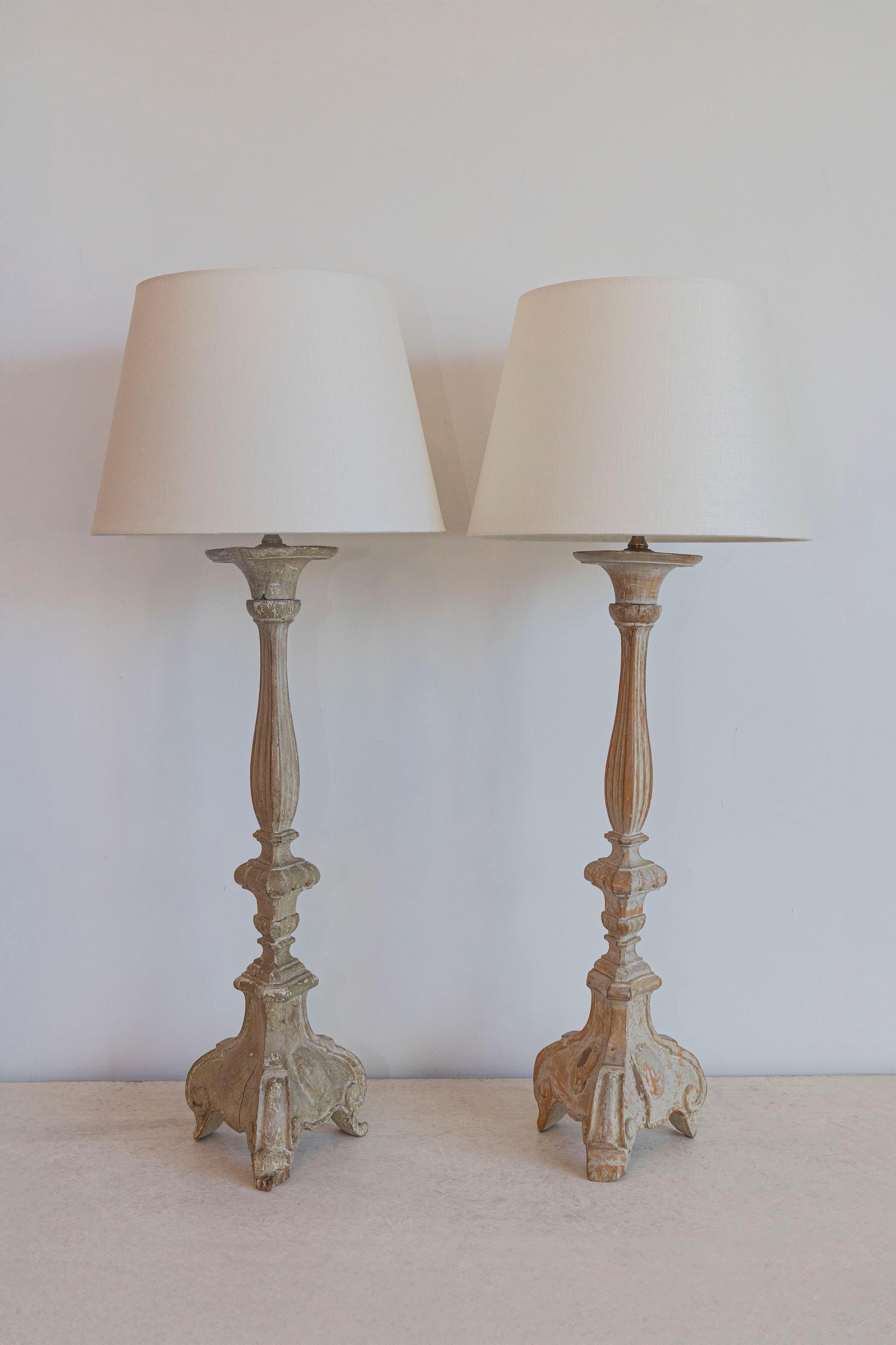 Cette paire de chandeliers français du XVIIIe siècle, transformés avec brio en élégantes lampes de table, incarne la beauté intemporelle du design français. Sculptées à l'origine comme des chandeliers ornés, ces pièces conservent leur charme
