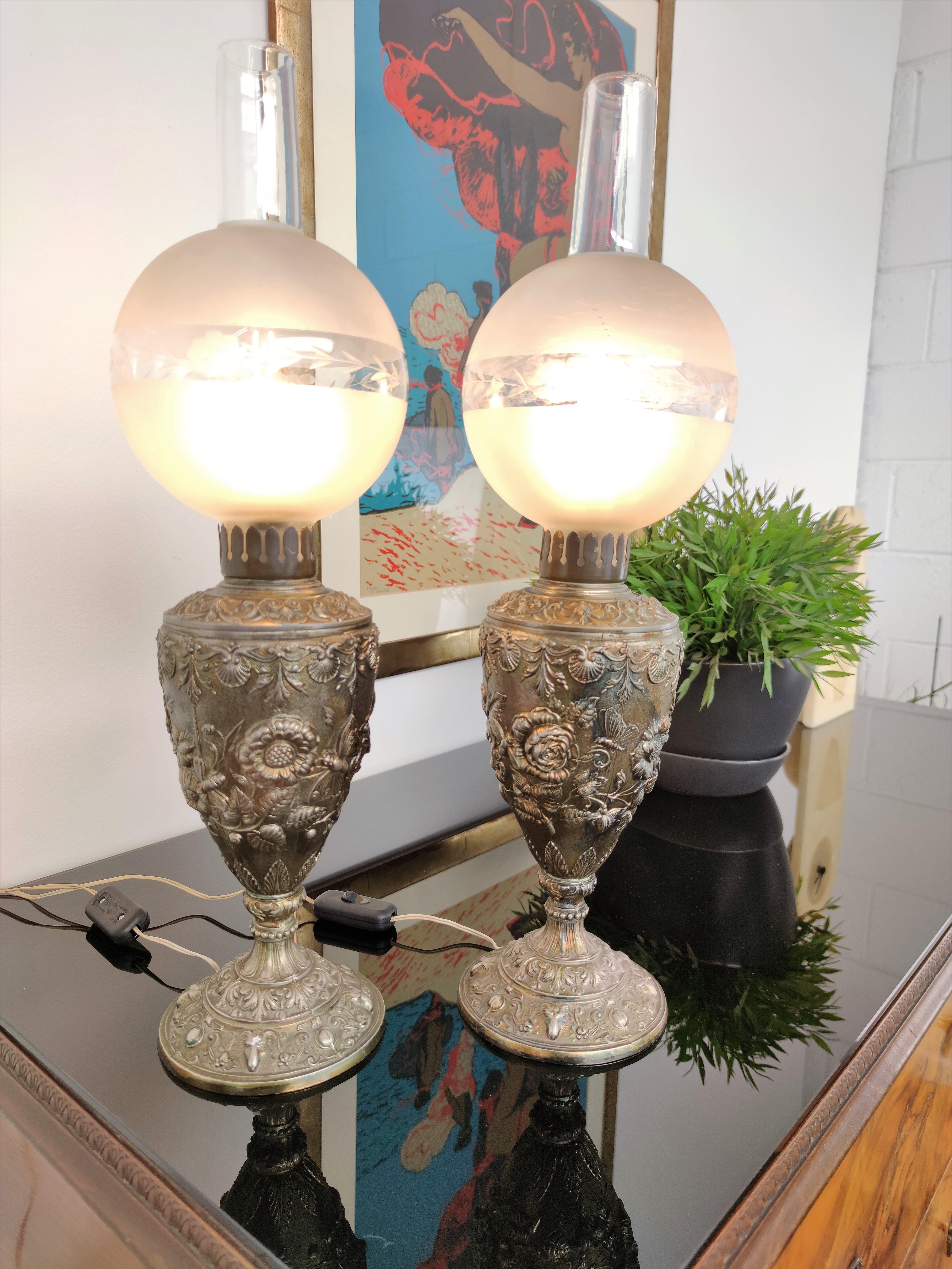 Beautiful pair of Italian table lamps in gilt bronze with the typical urn shape of oil lamps converted to electric with the etched glass globe and top chimney. The design is inspired to nature and botanicals with a flair of Grecian classical