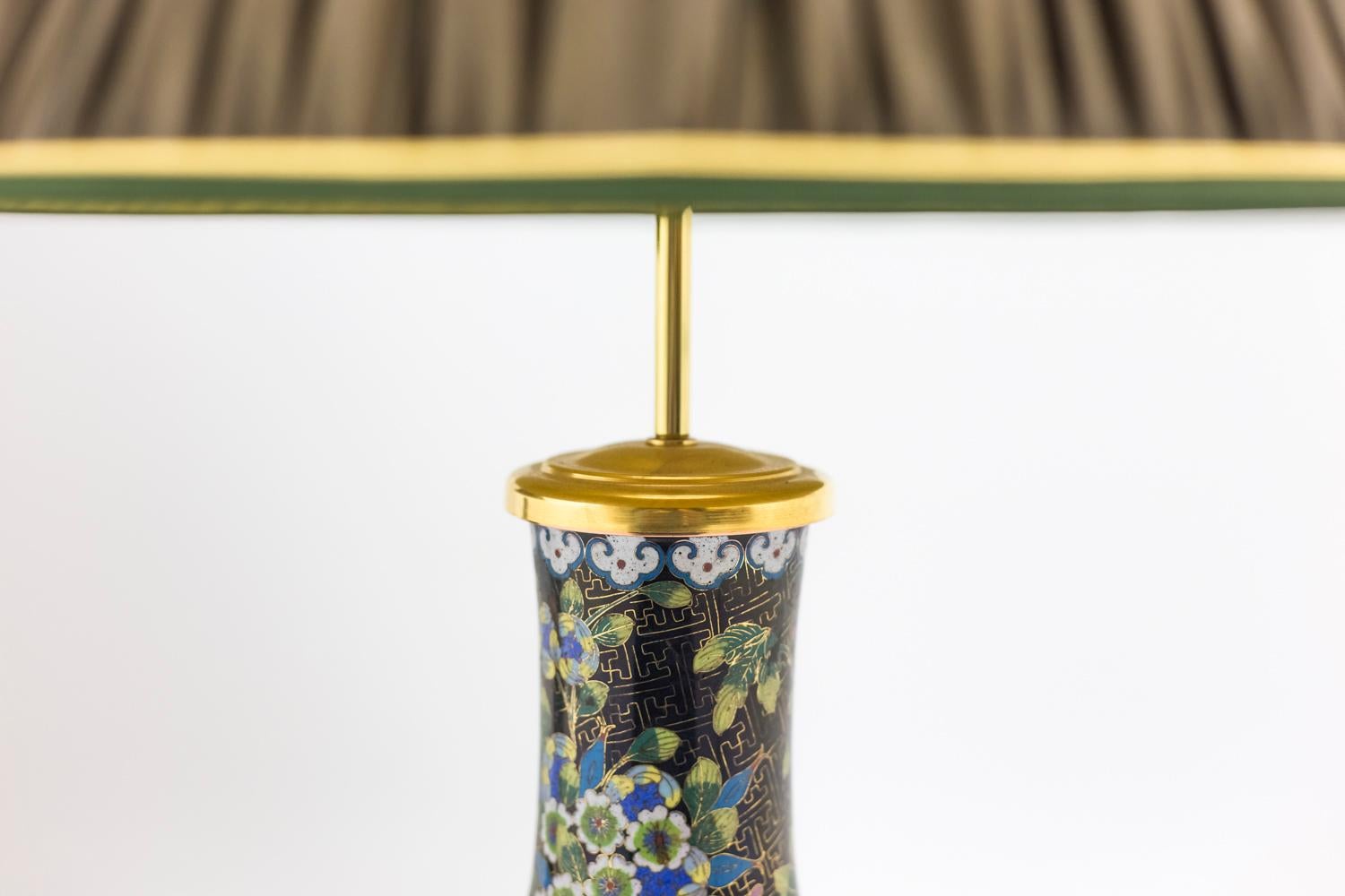 Origine : probablement Chine et France.

Paire de lampes en forme de bouteilles en émail cloisonné noir montées sur une monture en bronze ciselé et doré à base quadripode ornée d'un décor ajouré et ciselé de rinceaux et cartouches ; partie