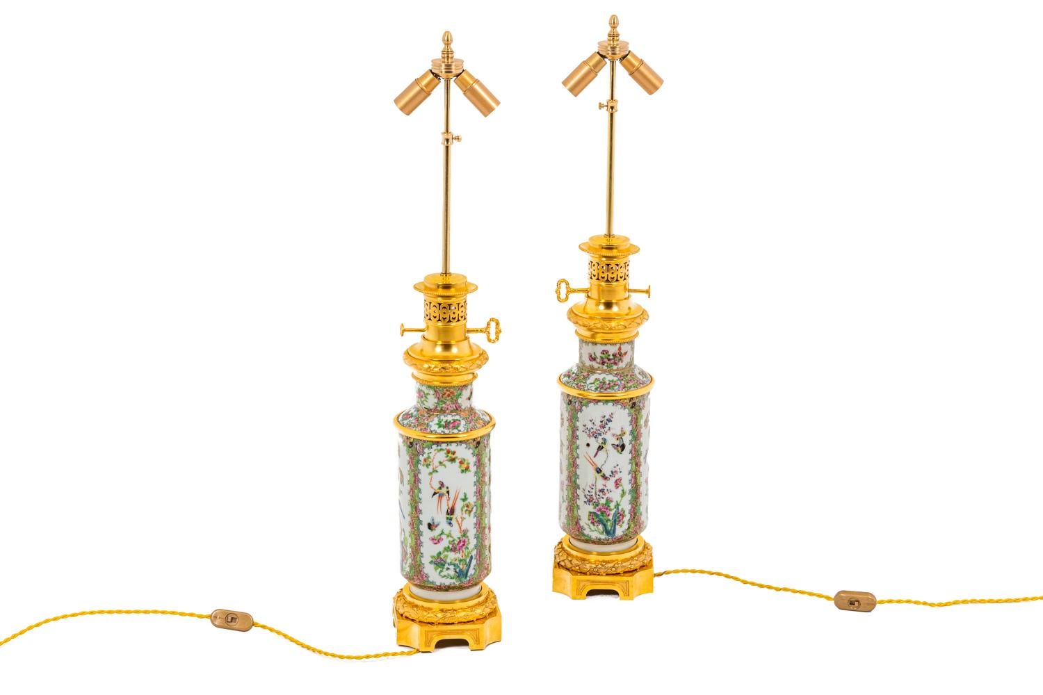 Pair of baluster-shape lamps in Canton porcelain. Decor with floral motifs framing birds and butterflies in a flower garden on a white background. Chiselled and gilt bronze mount. Hexagonal base.

Work realized in the 19th century.

 