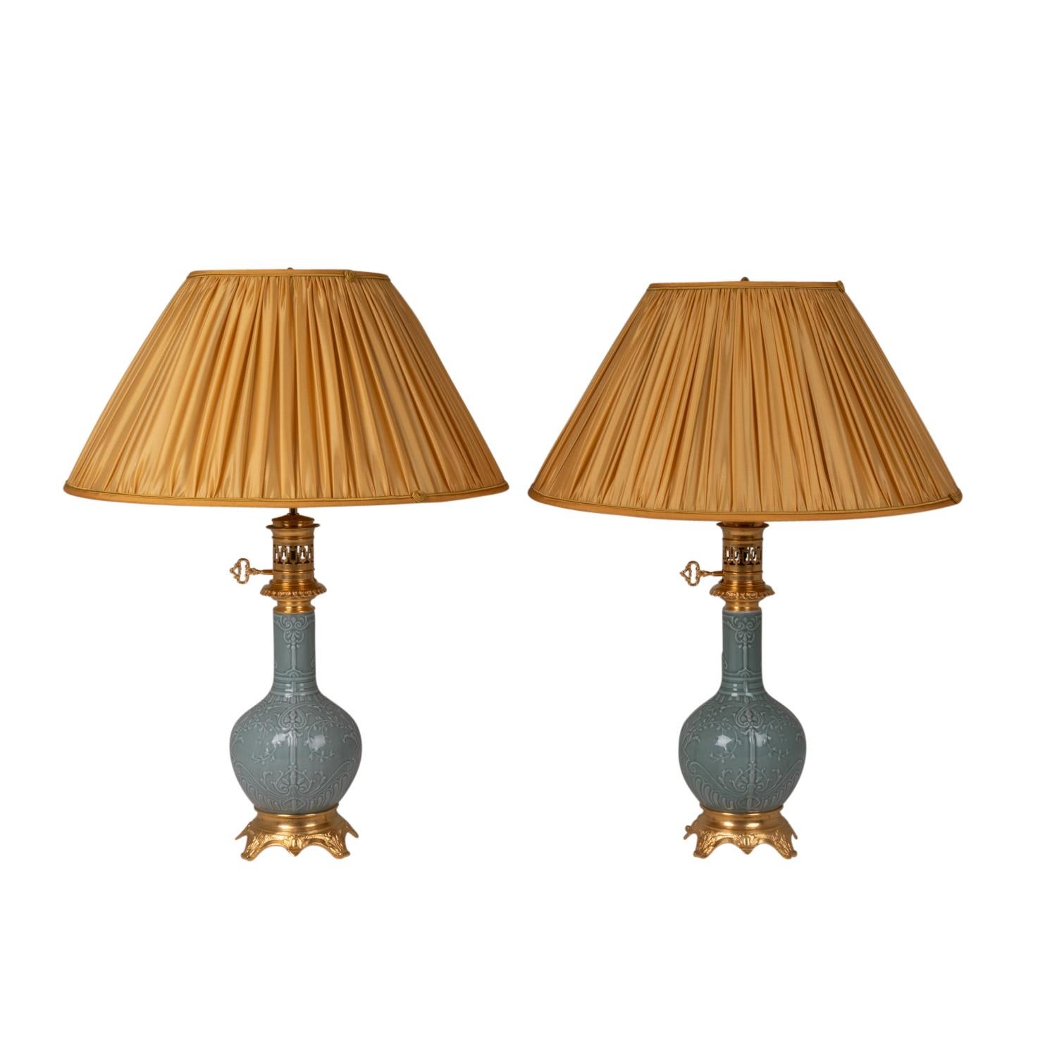 Pair of Celadon porcelain and gilt bronze lamps, with floral decoration in low relief and in baluster shape. Quadripod base adorned with leaves, concave in shape.

French work realized circa 1880.

!The price does not include the price of the
