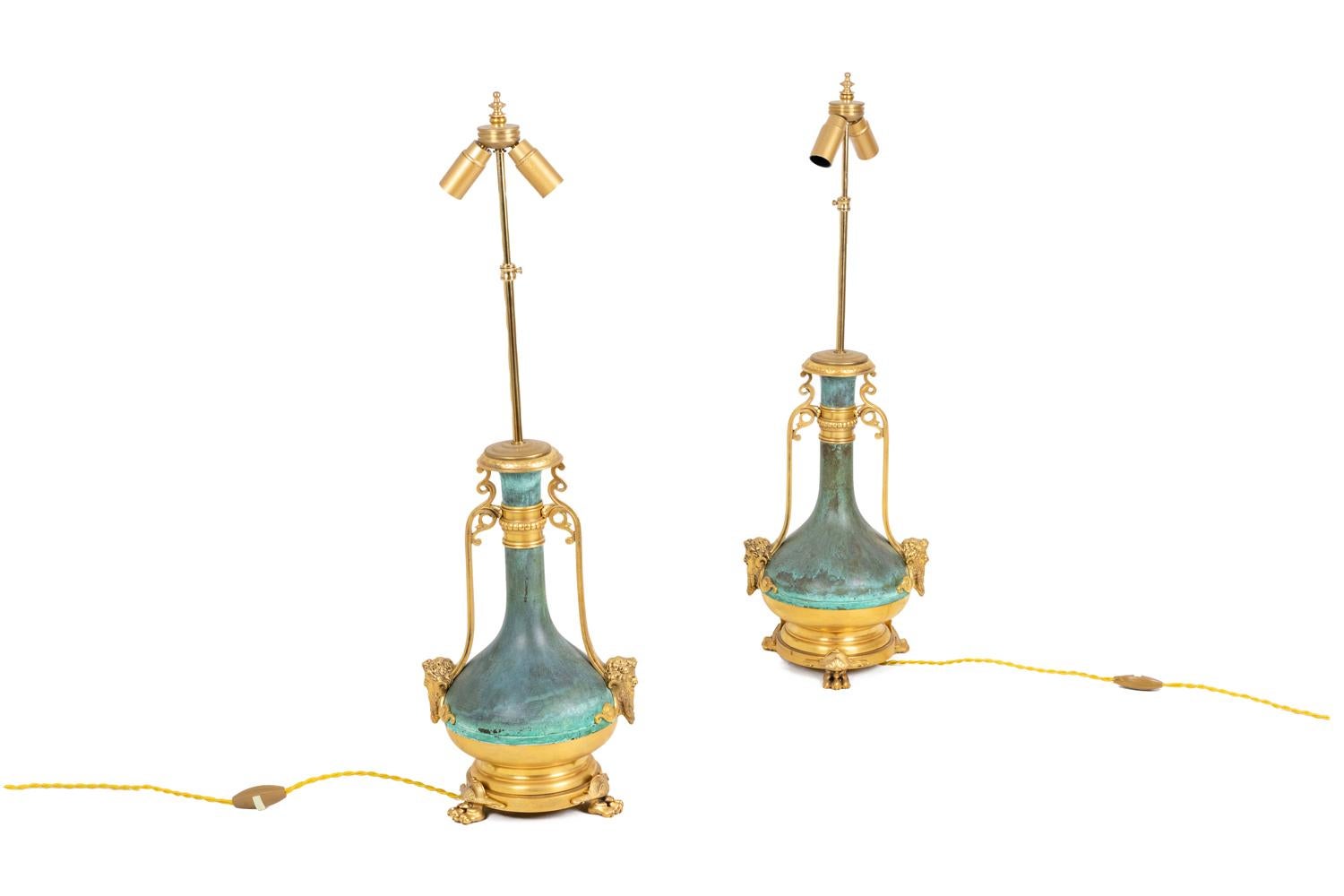 Pair of baluster shape lamps in green patinated and gilt brass.
Neck ring decorated with gadroons on a guilloche background. Two handles on each side in scrolls shape and adorned with faun heads. Circular tripod base with legs in lion paws