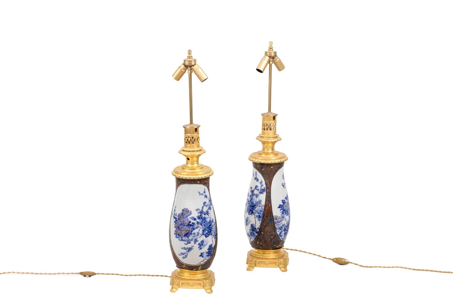 Coppia di lampade a forma di vaso in porcellana giapponese.
Decorazioni su sfondo marrone e motivi stilizzati di fiori, fogliame e uccelli nei toni del blu, del giallo e del rosso. Due grandi cartigli a sfondo bianco con un decoro blu che raffigura