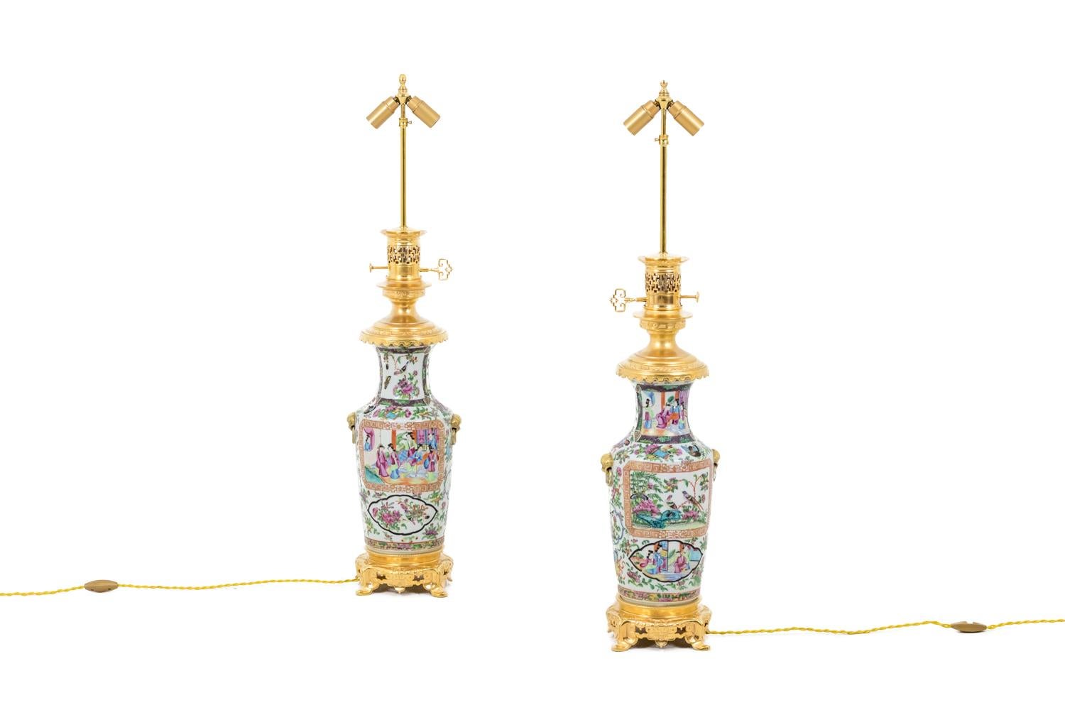 Pair of baluster shape Samson porcelain lamps in Canton porcelain imitation. Background decor figuring flowers, butterflies, weapons and writing tools. Cartouches decor with black, blue, orange Greek frieze shape and with a purple and green foliage