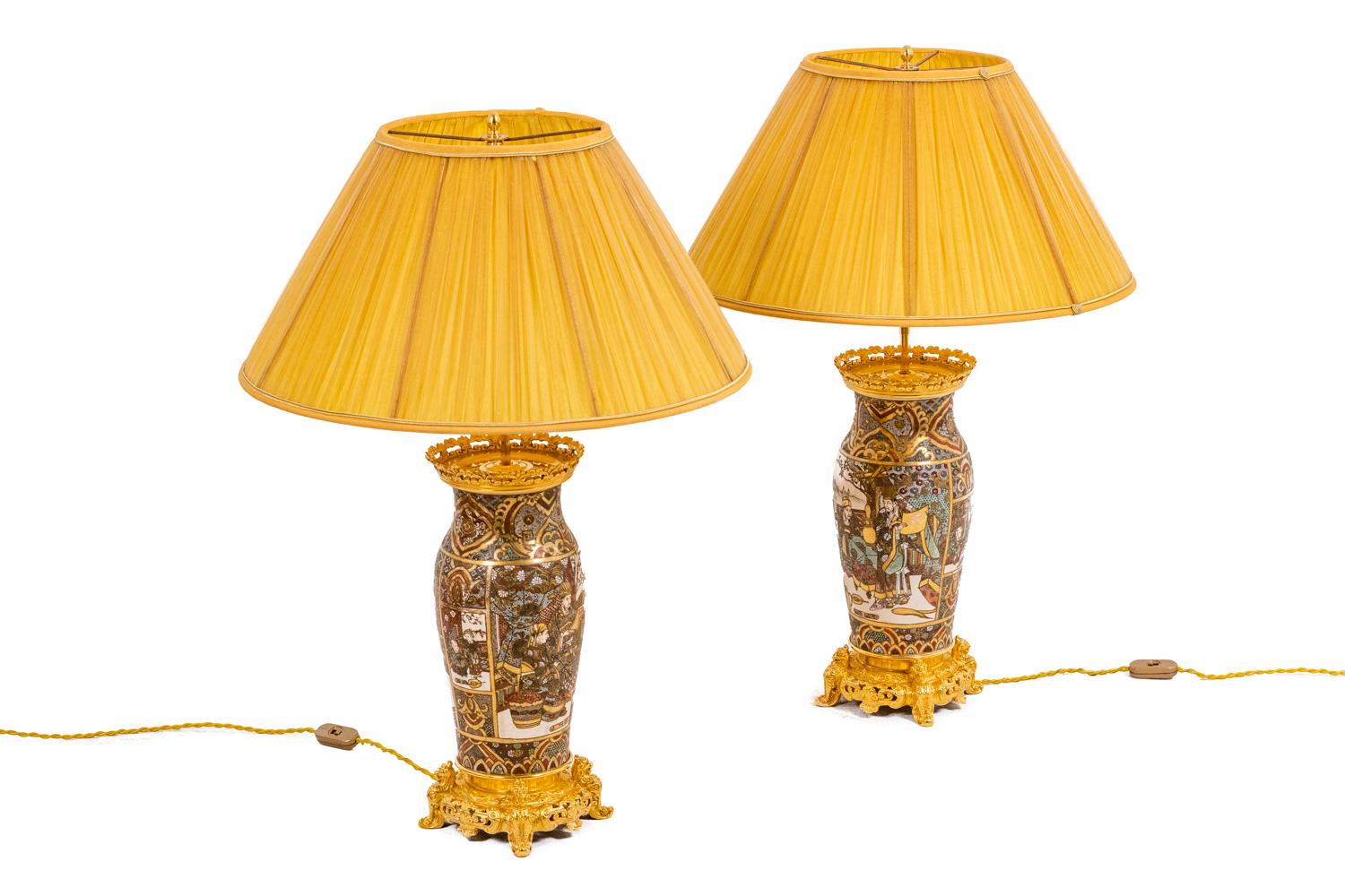 Pair lamps in fine earthenware from Satsuma gilt bronze adorned with characters. Color predominantly gold. Ovoid shape surmounted by a neck. White cartridges on a golden background. Base and frame in gilded and chiseled bronze with openwork,