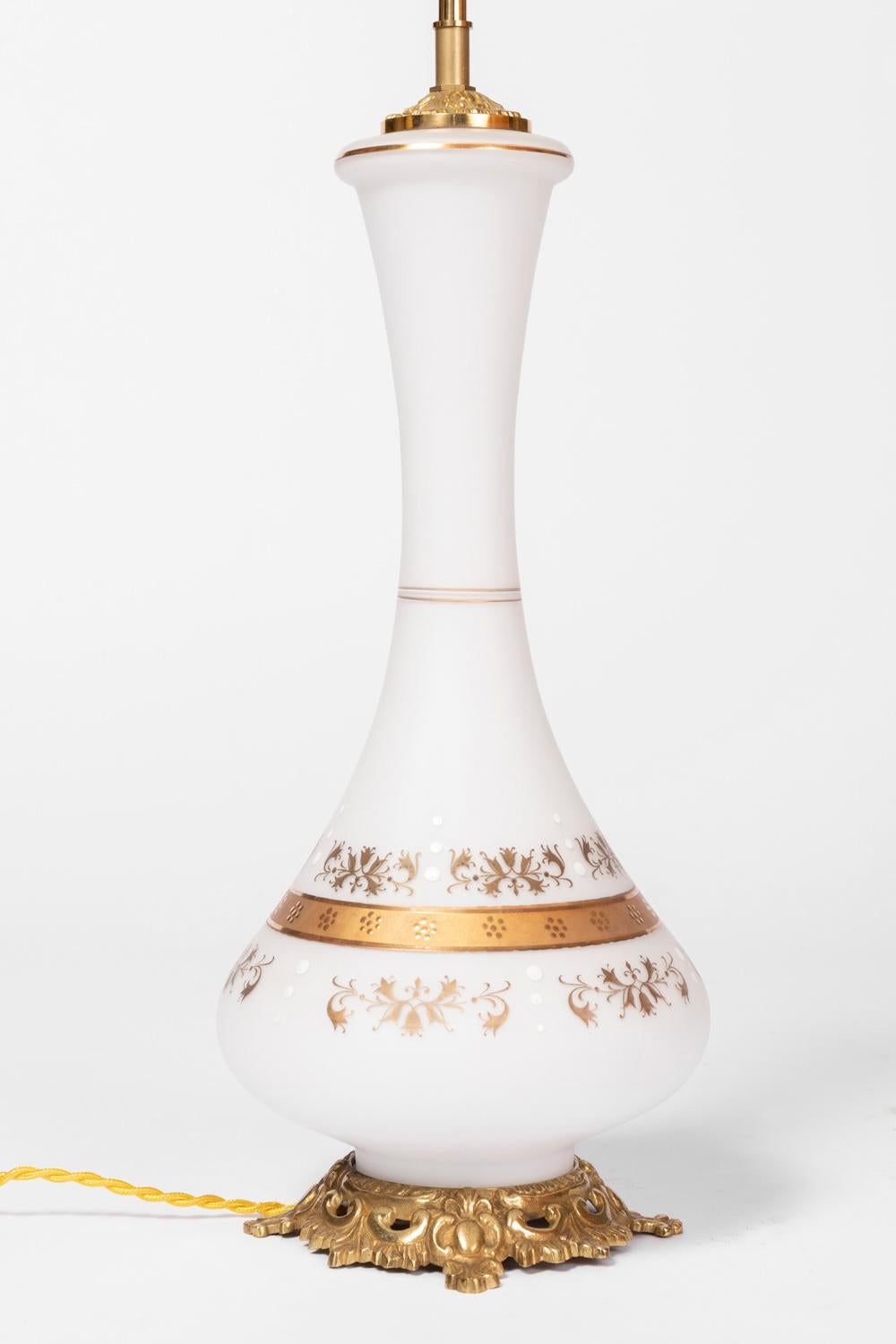 Pair of baluster shape lamps in white opaline. Decor of gilt edgings with dots motifs and adorned on the top and the bottom by gilt foliage scrolls and white dots. Two gilt edgings adorned the thinnest part of the necj and another on the high part