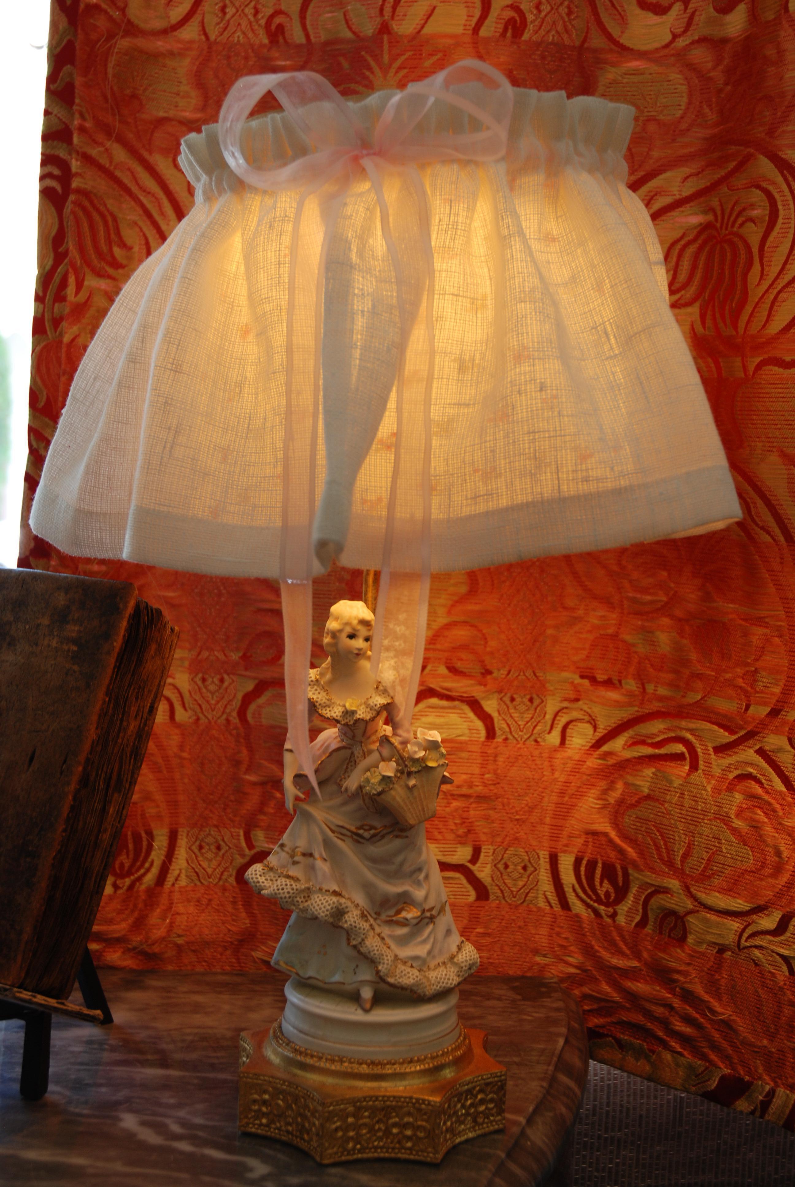 Pair of lamps made of Porcelain biscuit in the style of an 18th century couple.
Base is a lady for one lamp and a gentleman is the base of the other lamp.
Delicately hand-painted
Bottom support is gold leaf
Ruffled lampshades made of cream