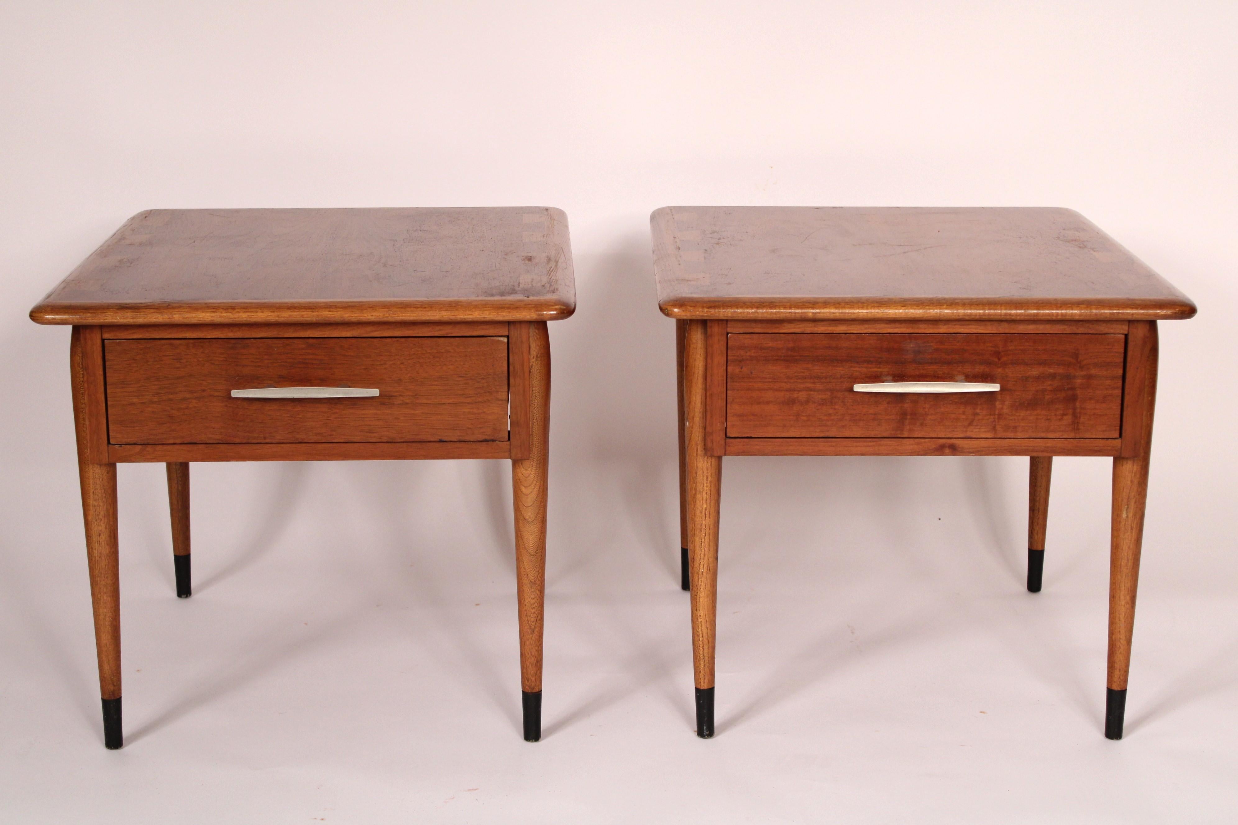 Pair of Lane midcentury modern end tables, circa 1960's. With a walnut rectangular overhanging top with rounded corner and elm dovetails, a dovetailed drawer with nickel hardware, resting on turned tapered legs.
Bottom stenciled, design patent