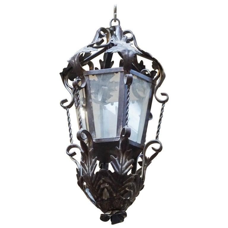 This French porch lantern is made of hand wrought iron with acanthus leaf decor. Arm included. Measurements: 13
