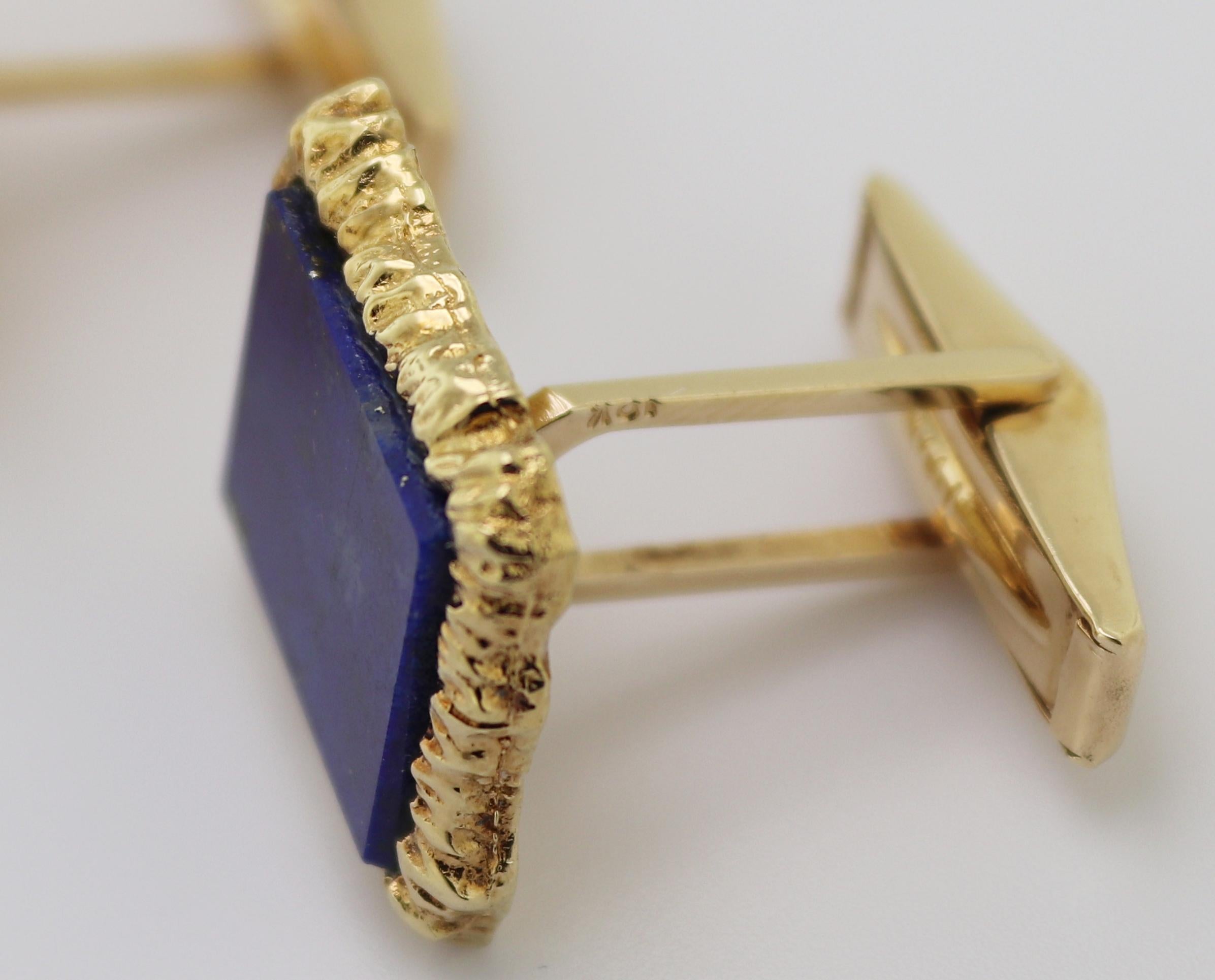 Chacune d'elles comporte (1) tablette rectangulaire en lapis-lazuli, 14 X 12 X 1,6 mm, sertie dans une boîte en métal.
une monture rectangulaire en or jaune 14k à texture irrégulière, 18.7 X
16,4 3,2 mm, complétées par des dos tournants en or jaune